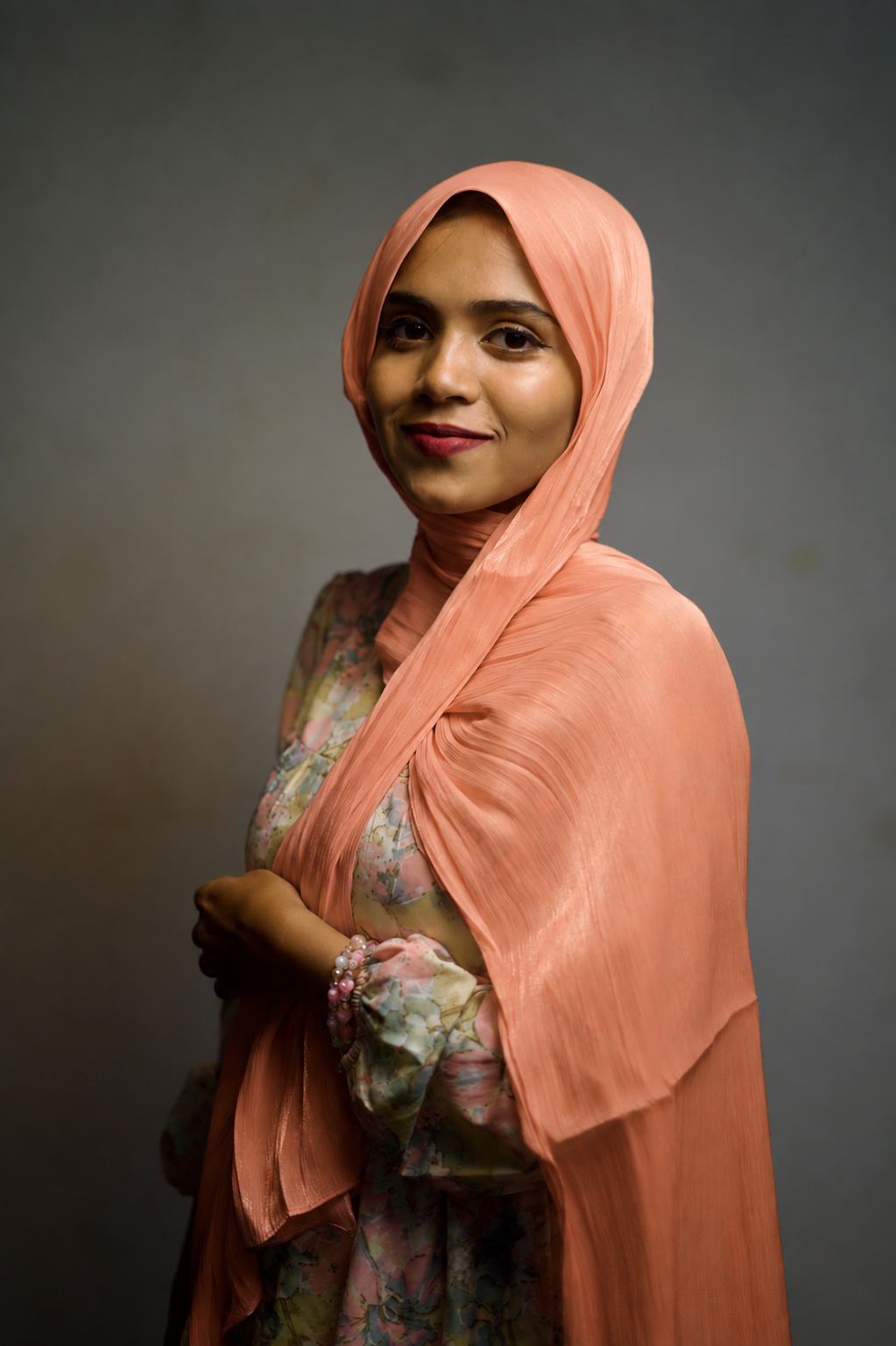 Woman wearing Atomic Tangerine shimmer hijab with elegant draped styling.