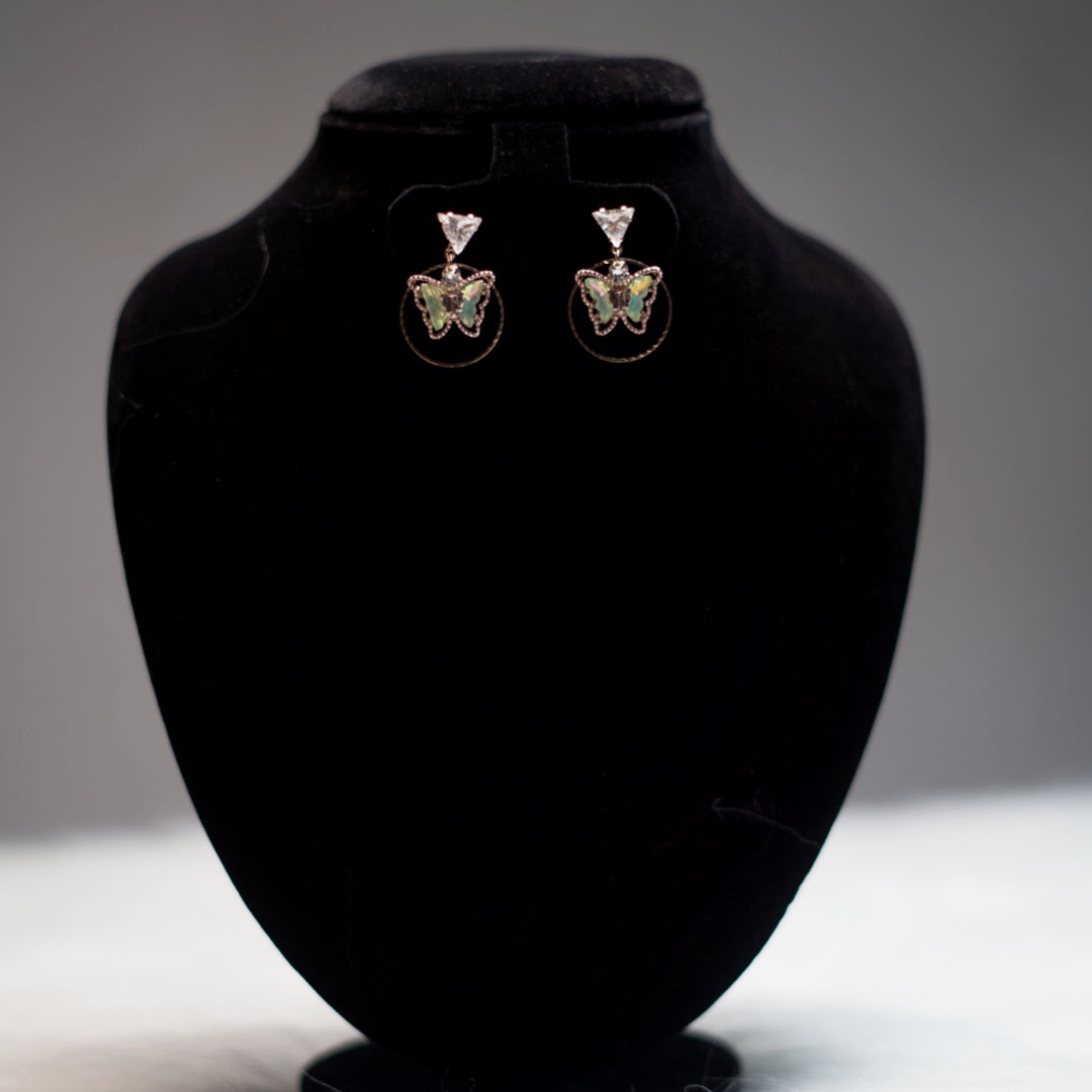 Iridescent green butterfly charm earrings with rose gold hoops and crystal top studs for an elegant finish.