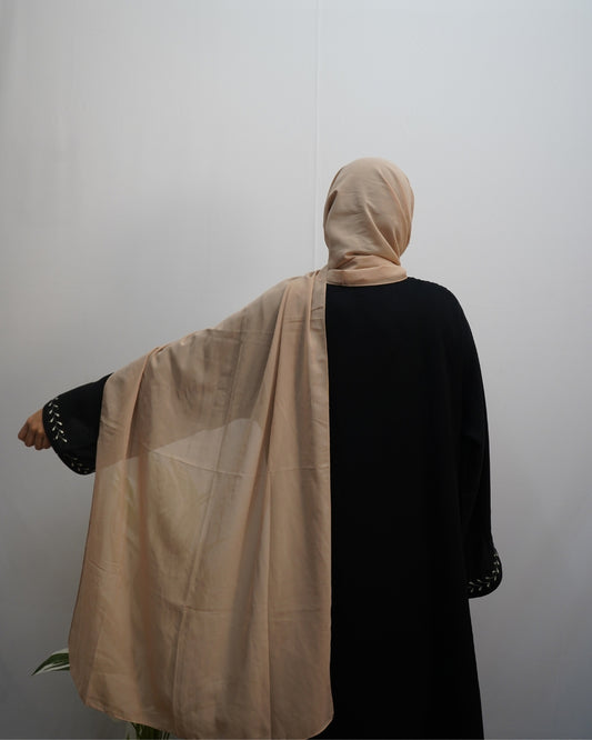 Lightweight beige indian chiffon hijab draped over black abaya.