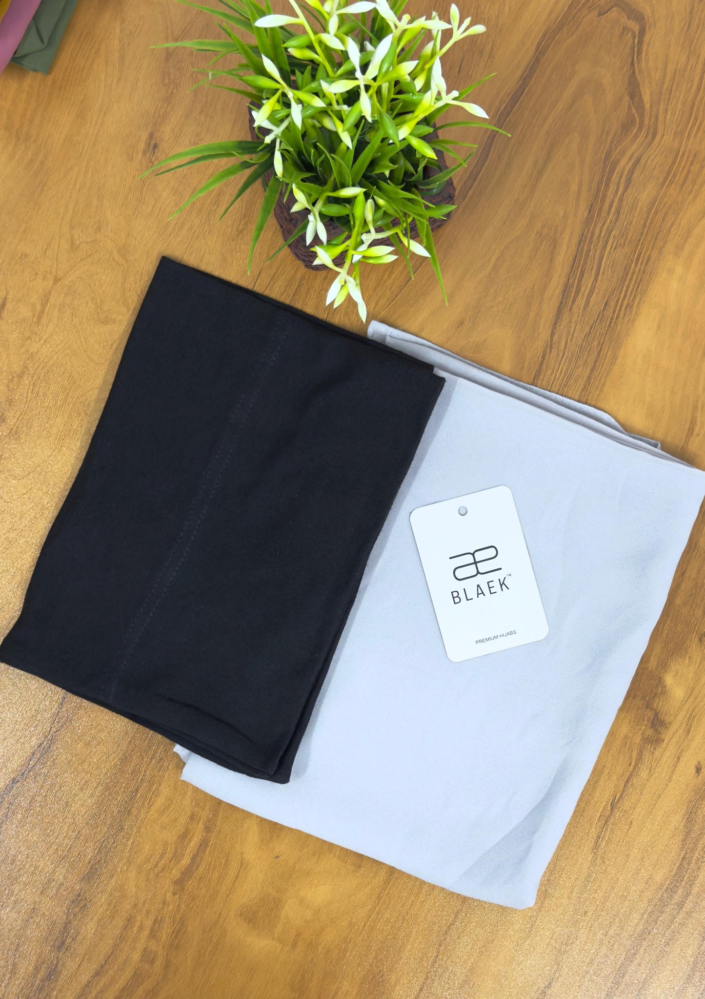 Graceful silver hijab matched with a deep black cap for a bold, stylish contrast.