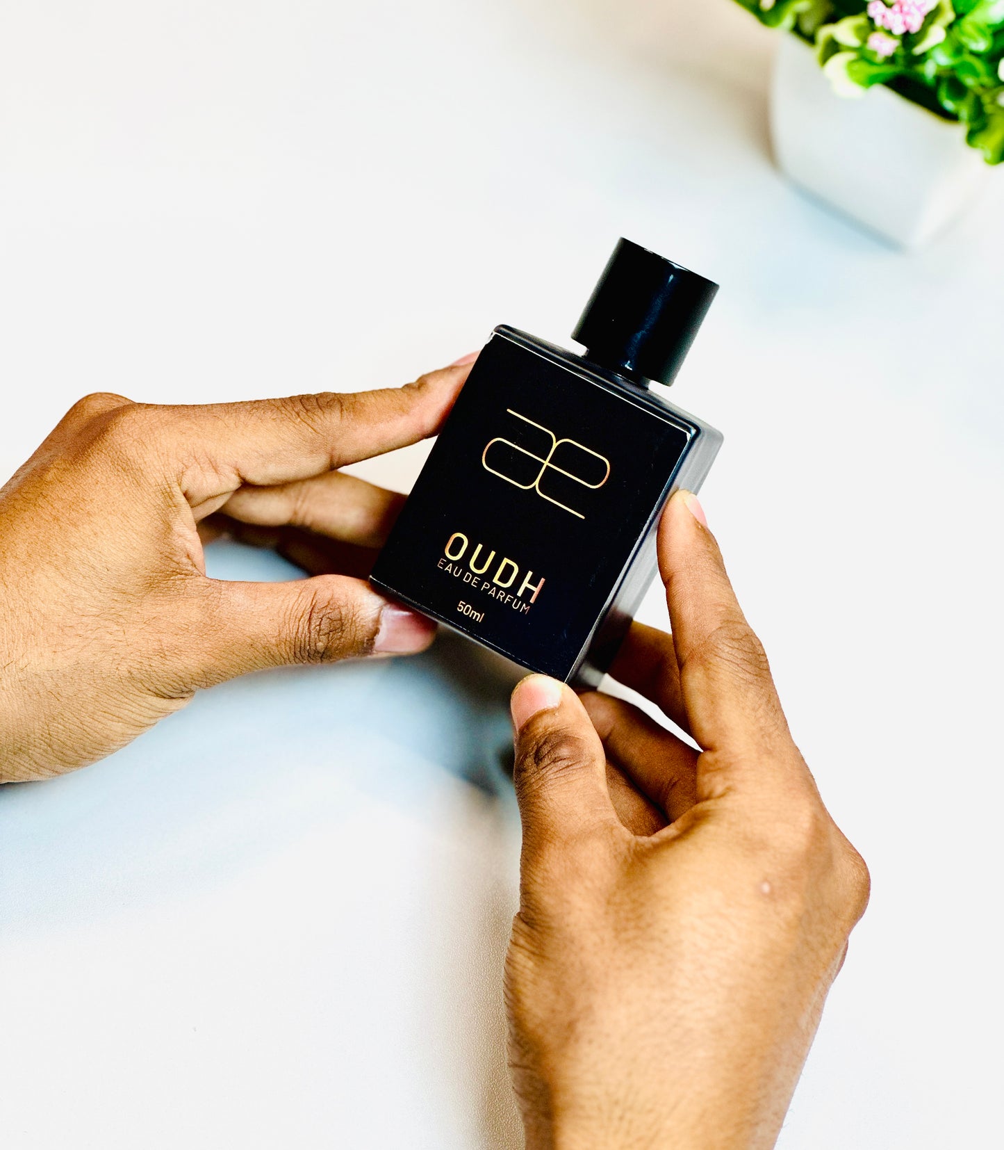 Hand holding Blaek Oudh Perfume (50ml) upright for a clear front view.