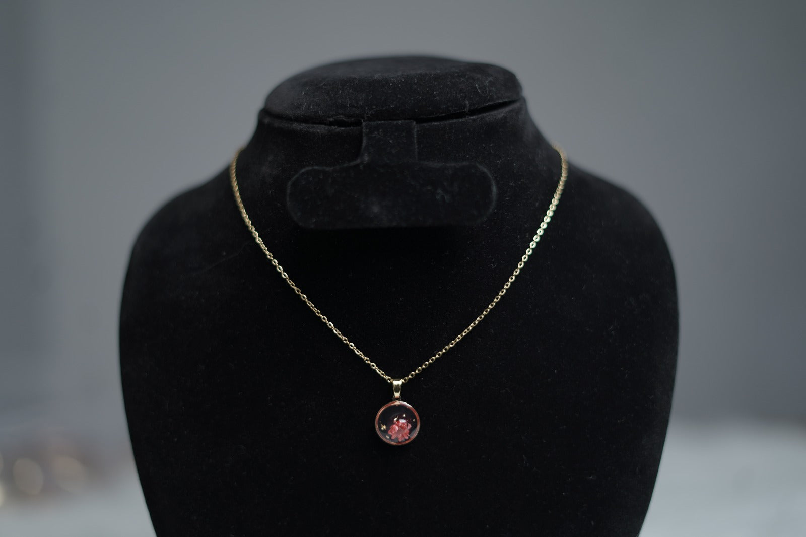 Close-up of Blush Bloom Necklace featuring dark pink resin flower pendant.