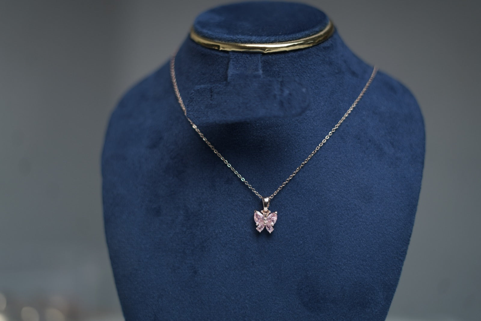 Close-up of pink butterfly pendant with sparkling crystals.