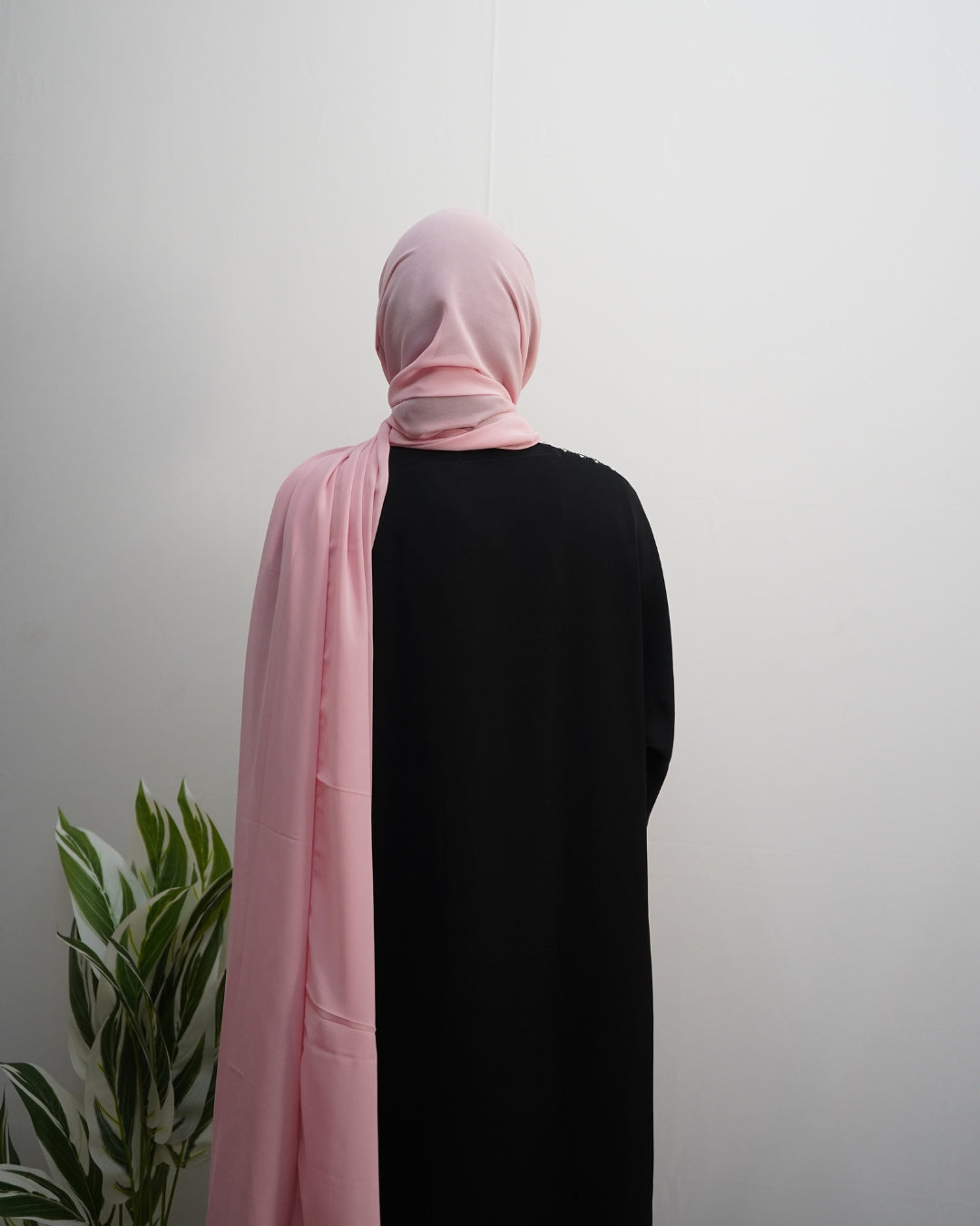 Elegant blush pink chiffon hijab styled with a flowy drape.