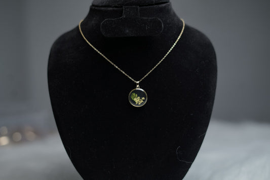 Botanical Bloom Necklace with dried flower pendant displayed on jewelry stand.