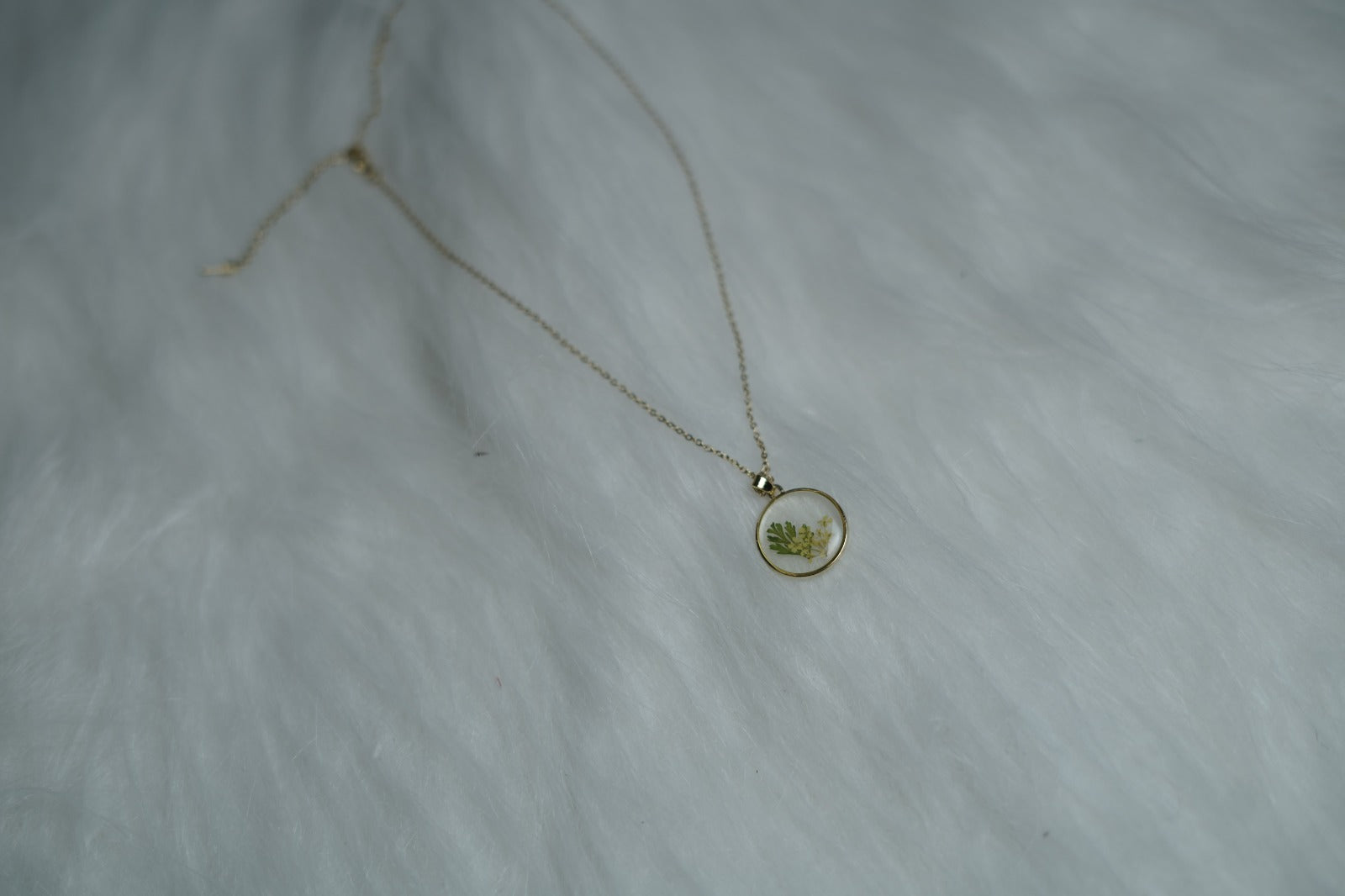 Close-up of Botanical Bloom pendant with yellow leaves and green flowers.