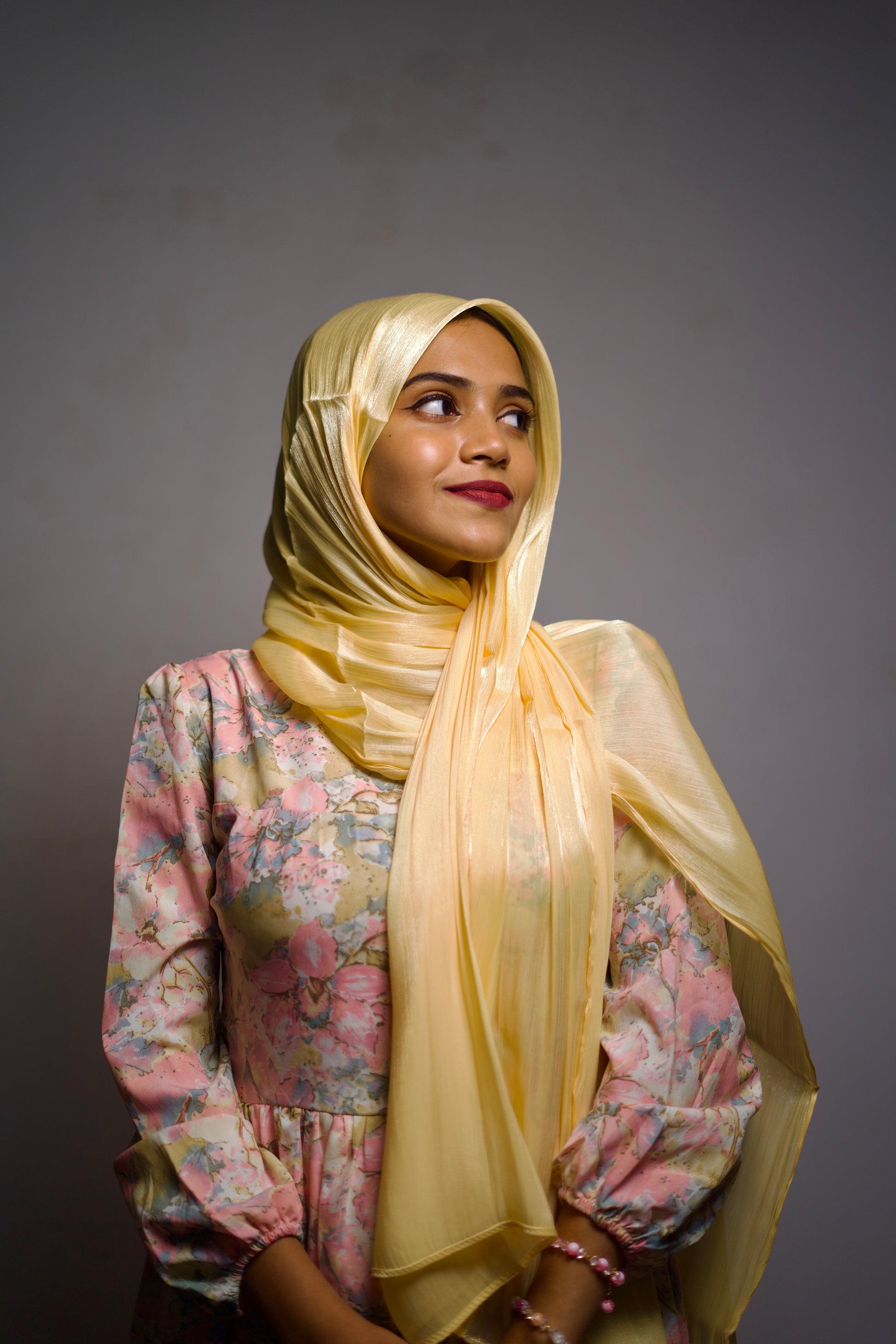 Brass yellow shimmer hijab worn plainly with a smooth front wrap.