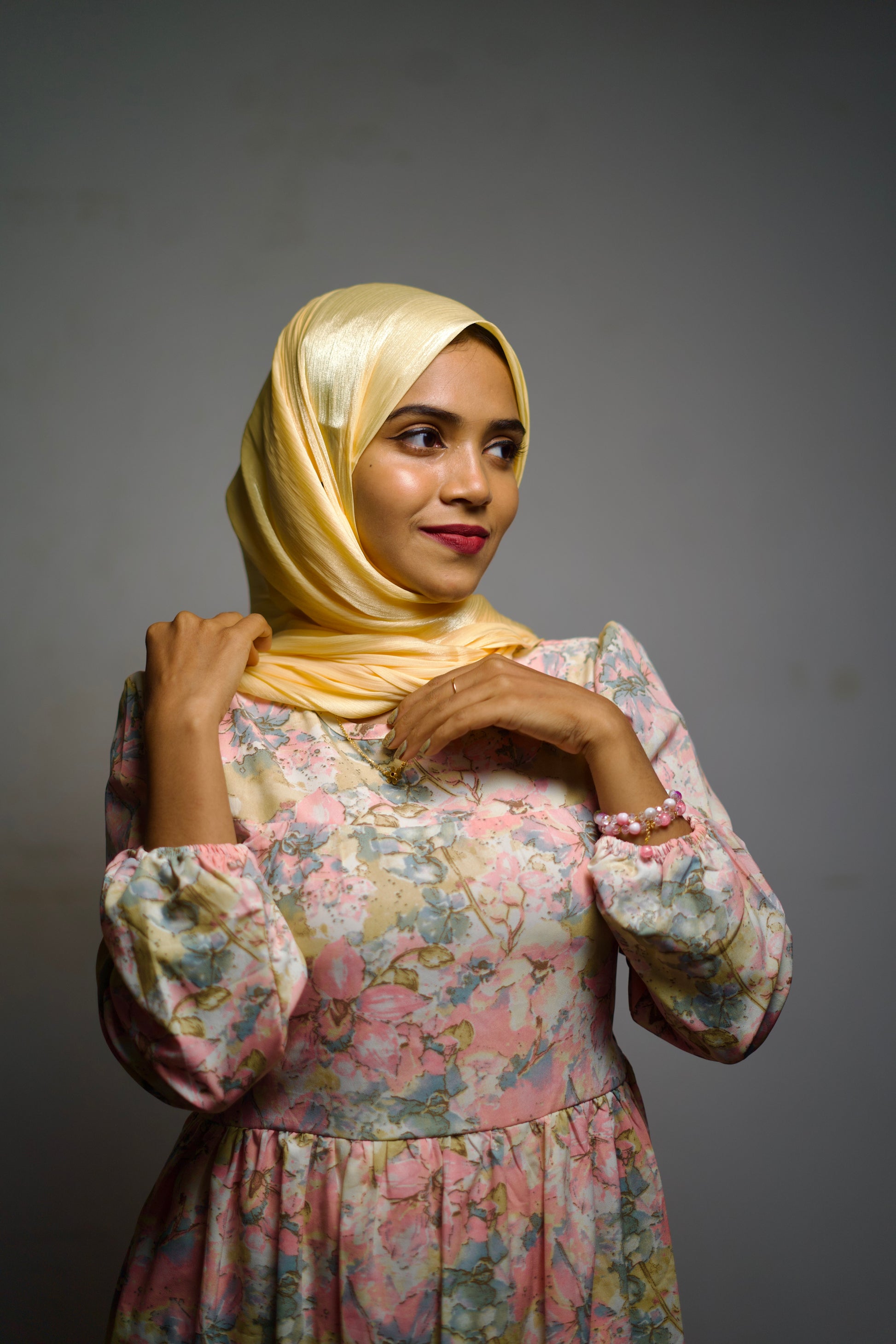 Brass yellow scarf with a glossy finish, worn gracefully around the head and neck.