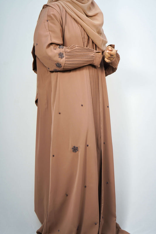 A full shot of the Korean Alqa Nidha Abaya in brown, hanging to showcase the overall design and length.