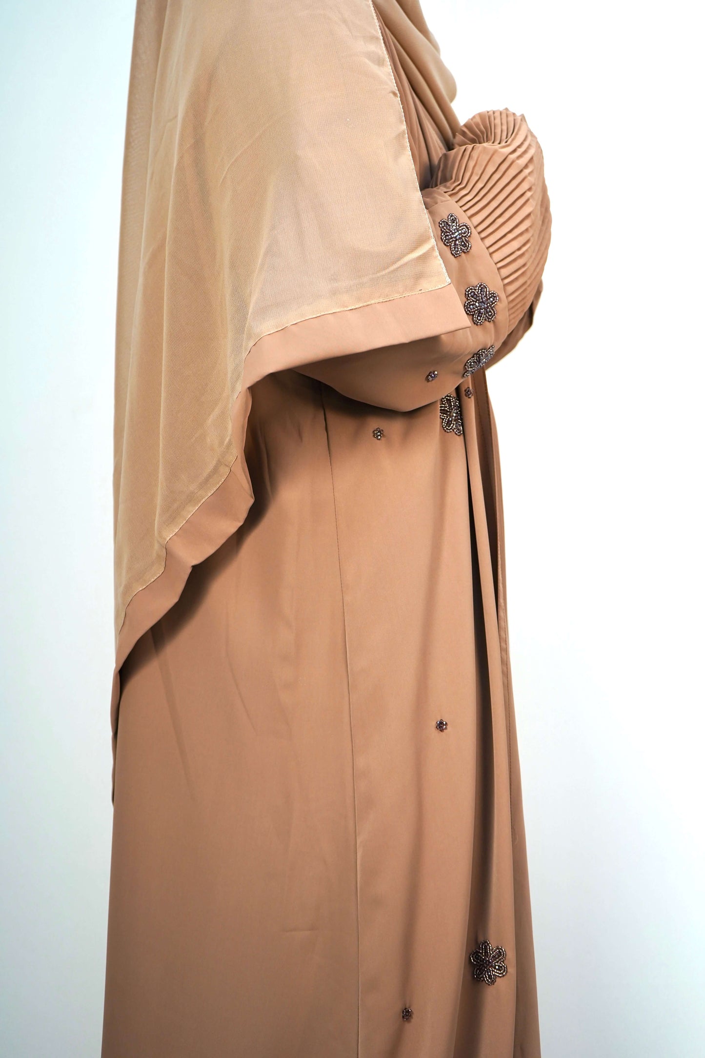 A side-on shot of the Korean Alqa Nidha Abaya in brown, showing the elegant flow of the layered fabric.
