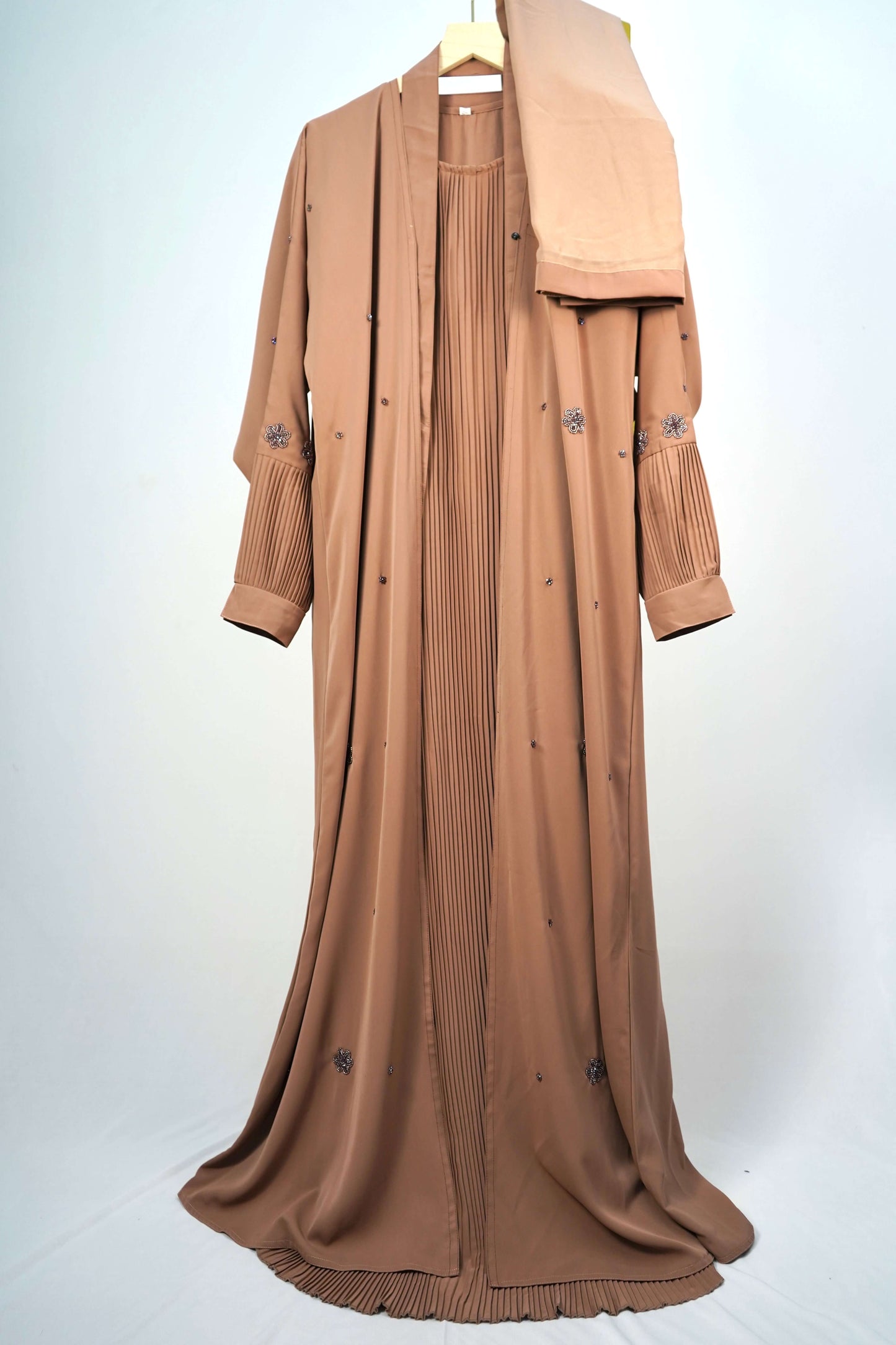 The Korean Alqa Nidha Abaya in brown, hanging with its matching scarf.