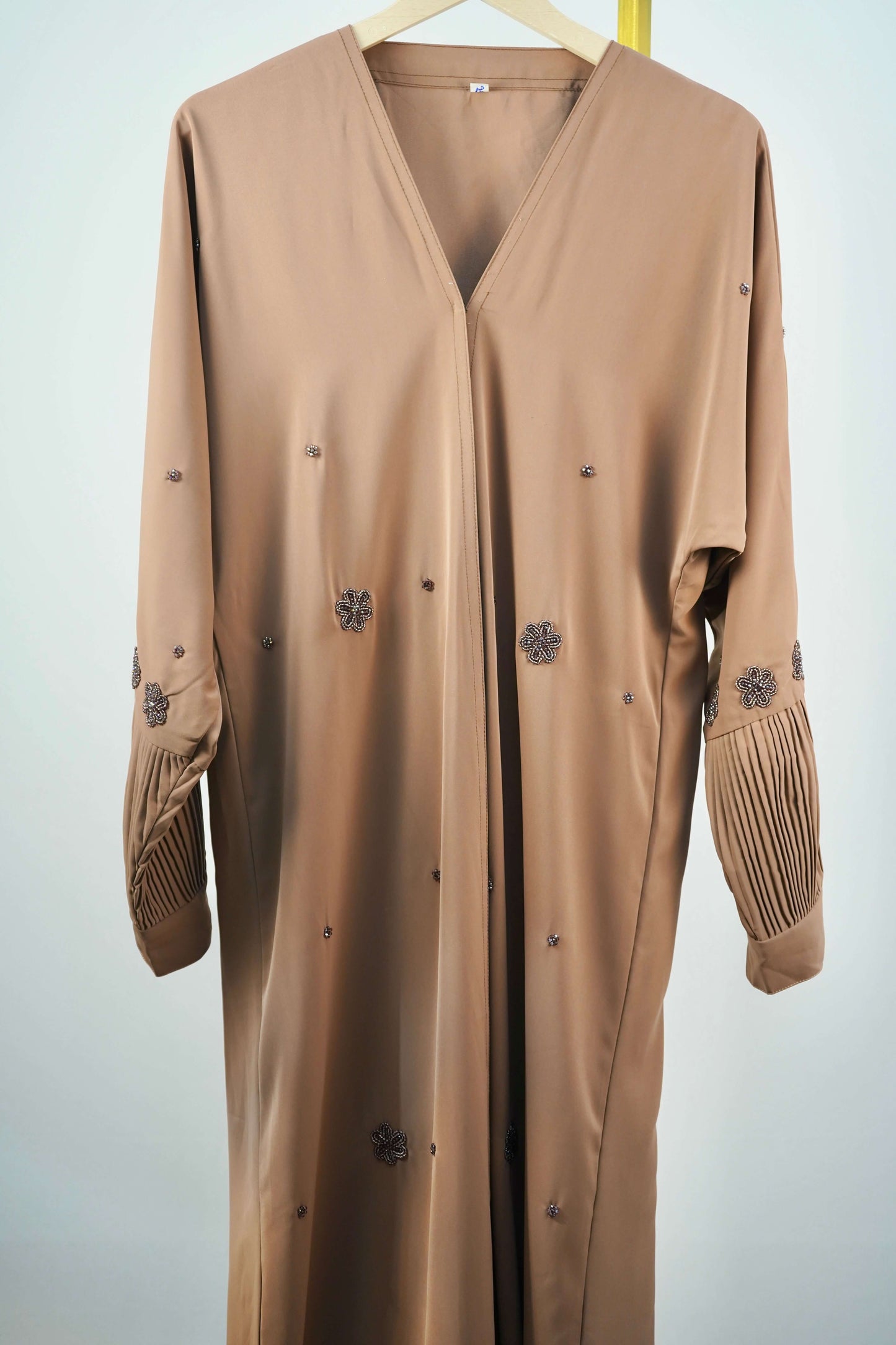 The smooth outer layer of the Korean Alqa Nidha Abaya in brown, showcasing its closed front design.