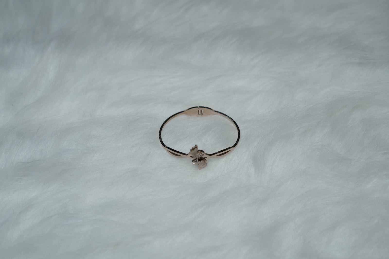 Butterfly Bloom Bangle on white background with gold infinity design and butterfly accents.