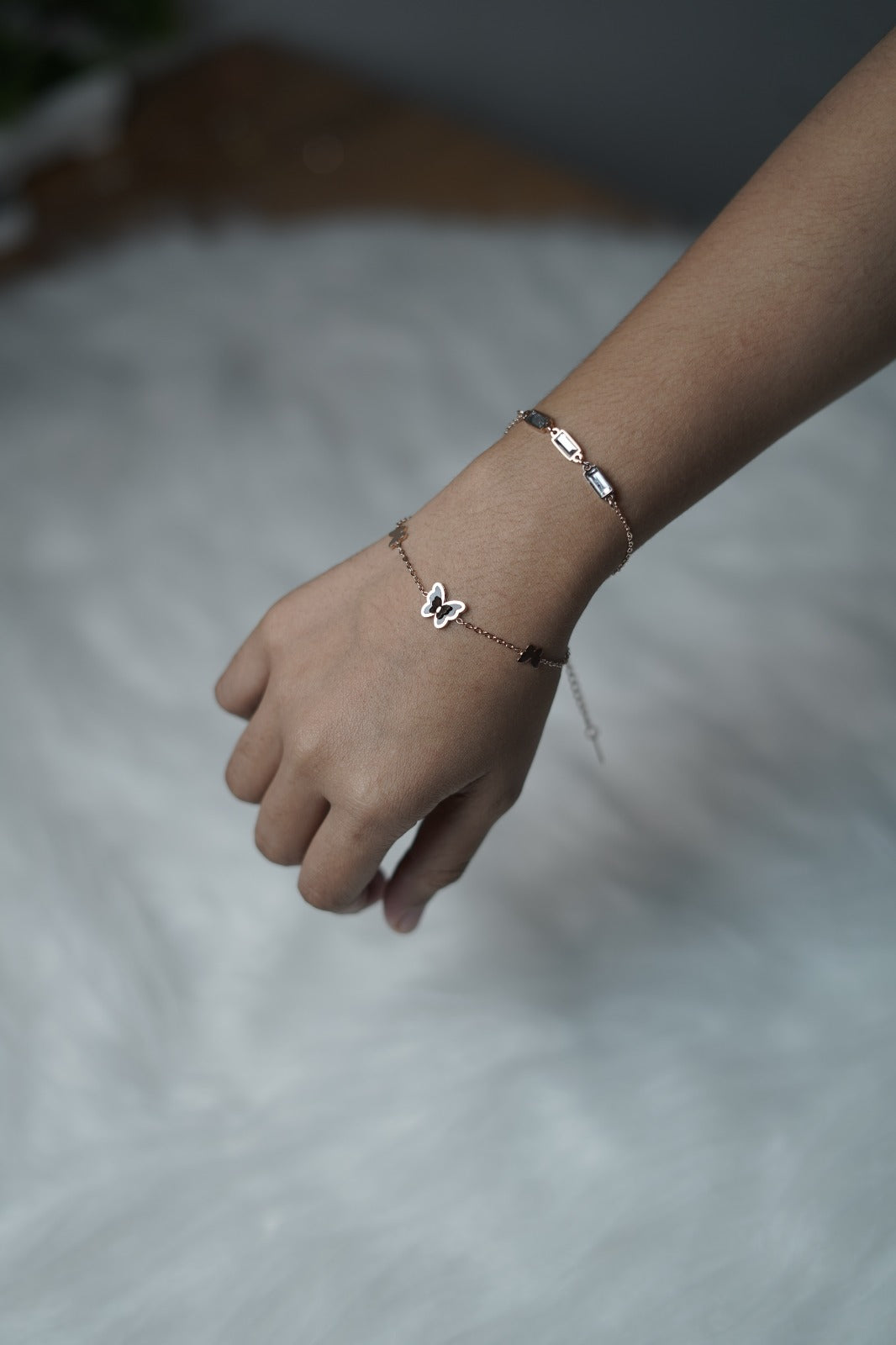 Butterfly Garden Bracelet worn on wrist, showing both chains and central butterfly charm.