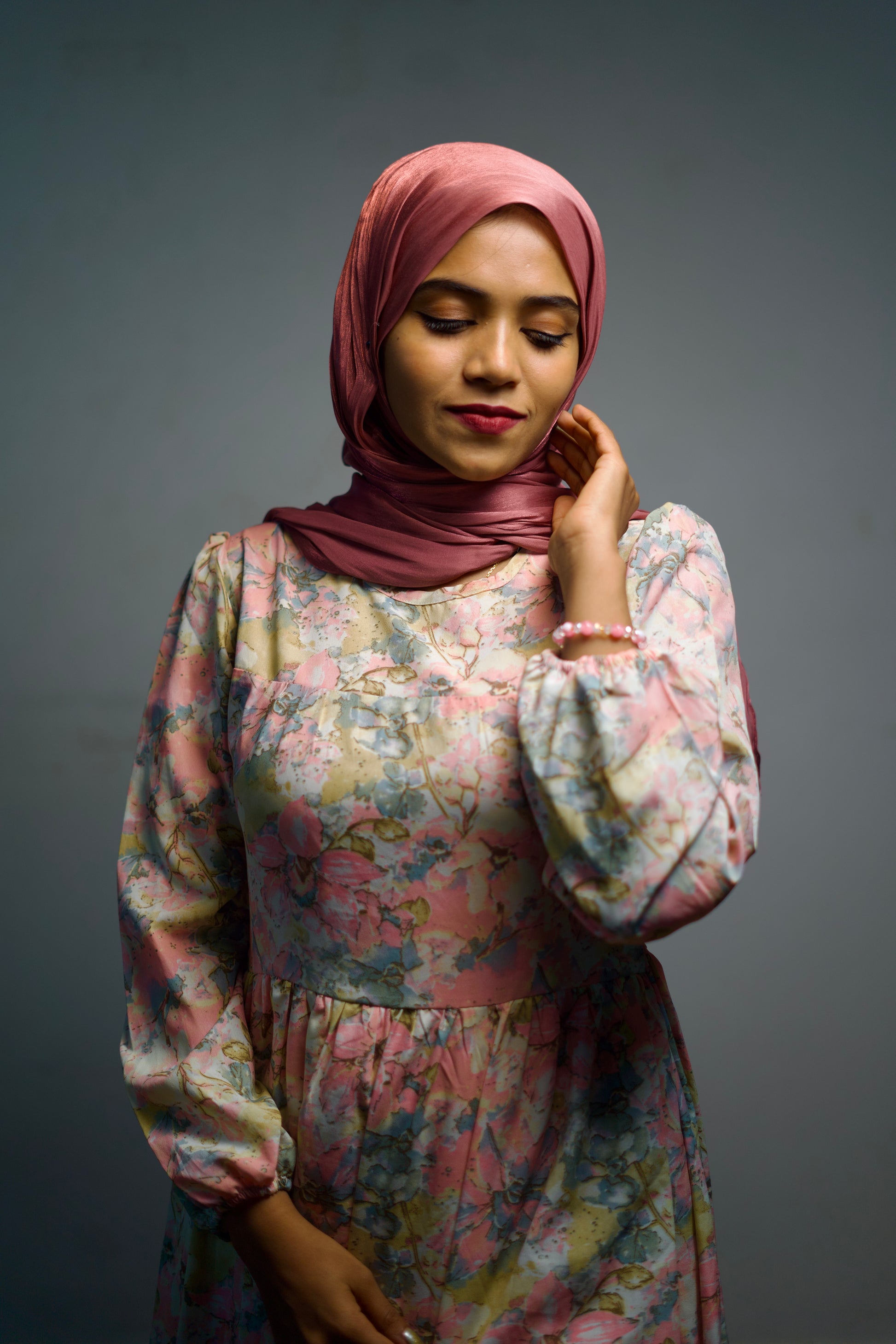 Shiny candy pink hijab styled gracefully around the face with gentle folds.