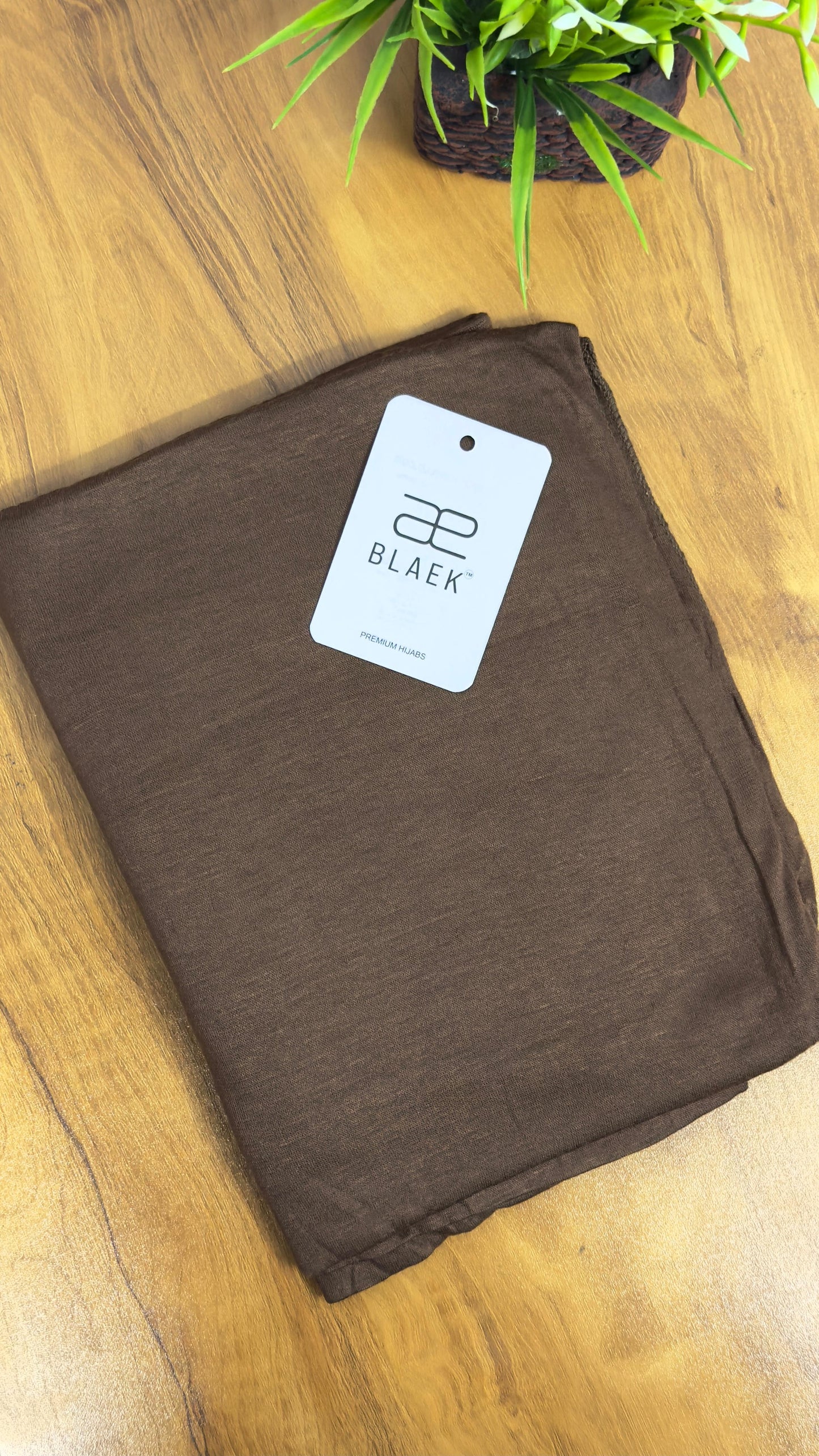 Deep coffee brown jersey hijab, folded with a smooth finish.
