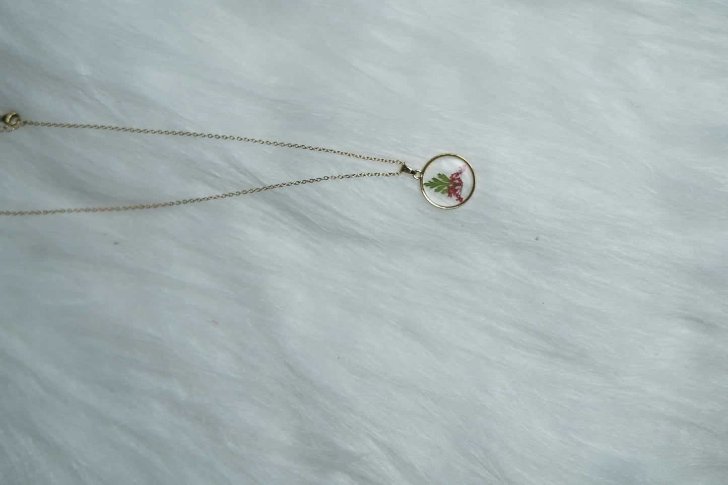 Crimson Leaf Necklace with red and green motif on white backdrop.