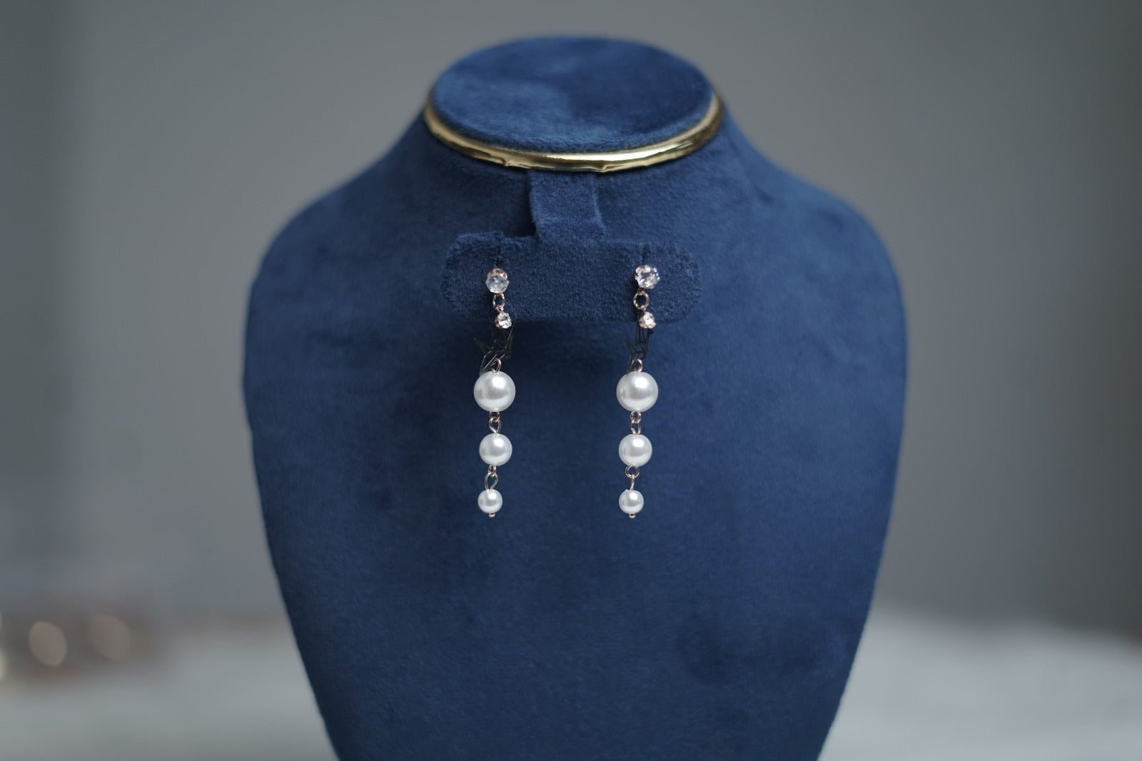 Detailed zoom showing crystal stud and rose gold chain.