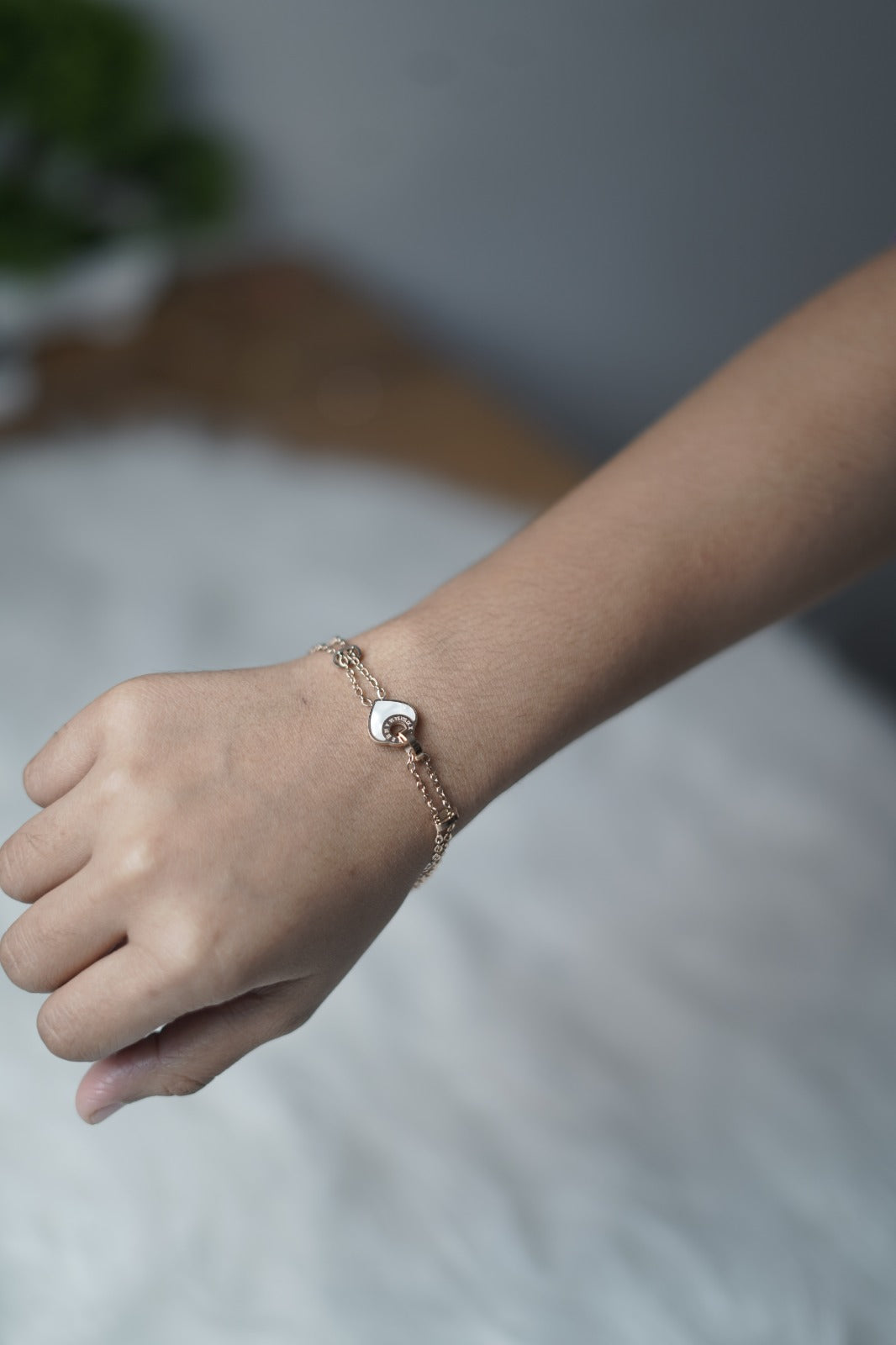 Dual Orbit Heart Bracelet worn on the wrist, highlighting its layered chain and tiny heart detail.