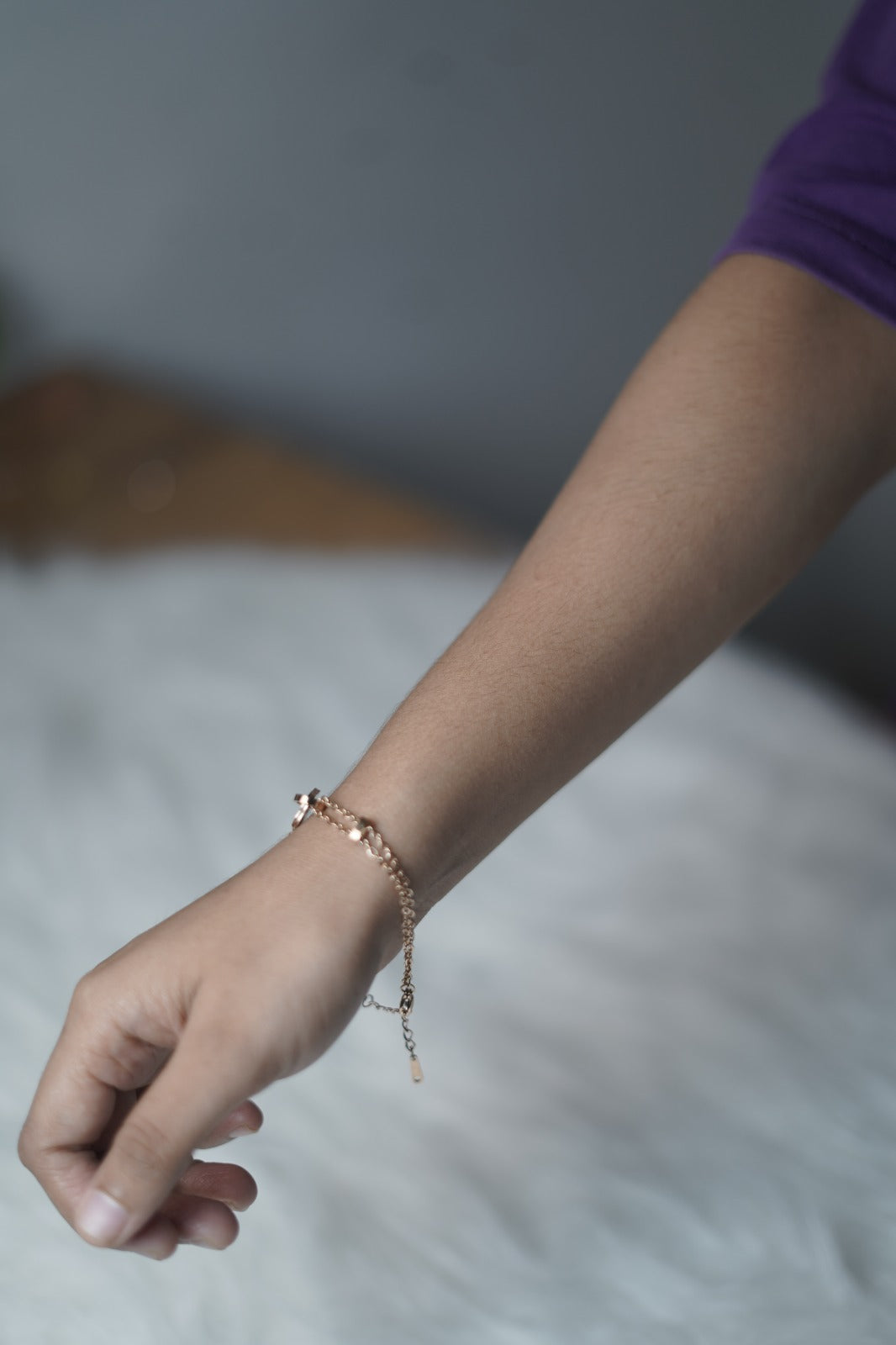 Close-up of the bracelet's heart charm wrapped in a circular frame, connected to dual delicate chains.