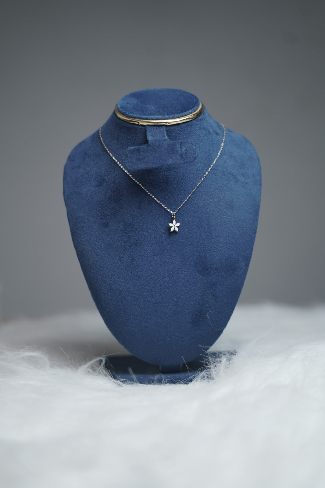 White petal pendant of reversible necklace styled on jewelry bust.