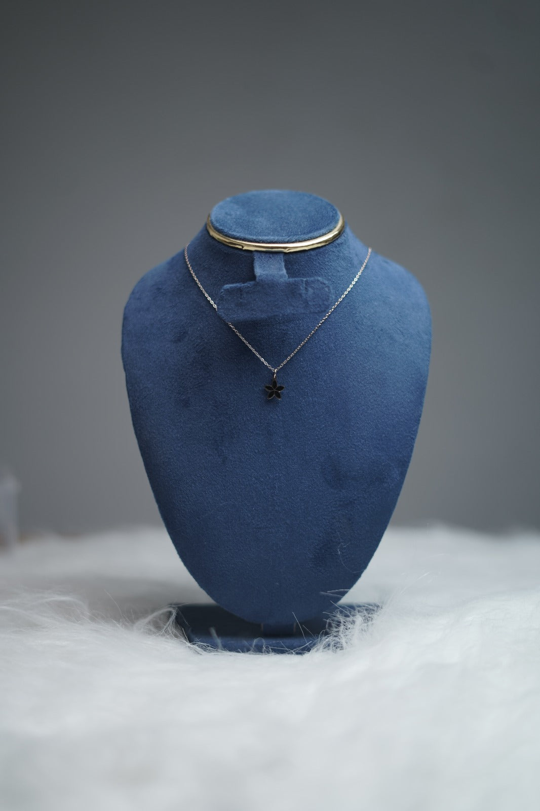 Dual Sided Bloom Petal Necklace (black side) displayed on stand.