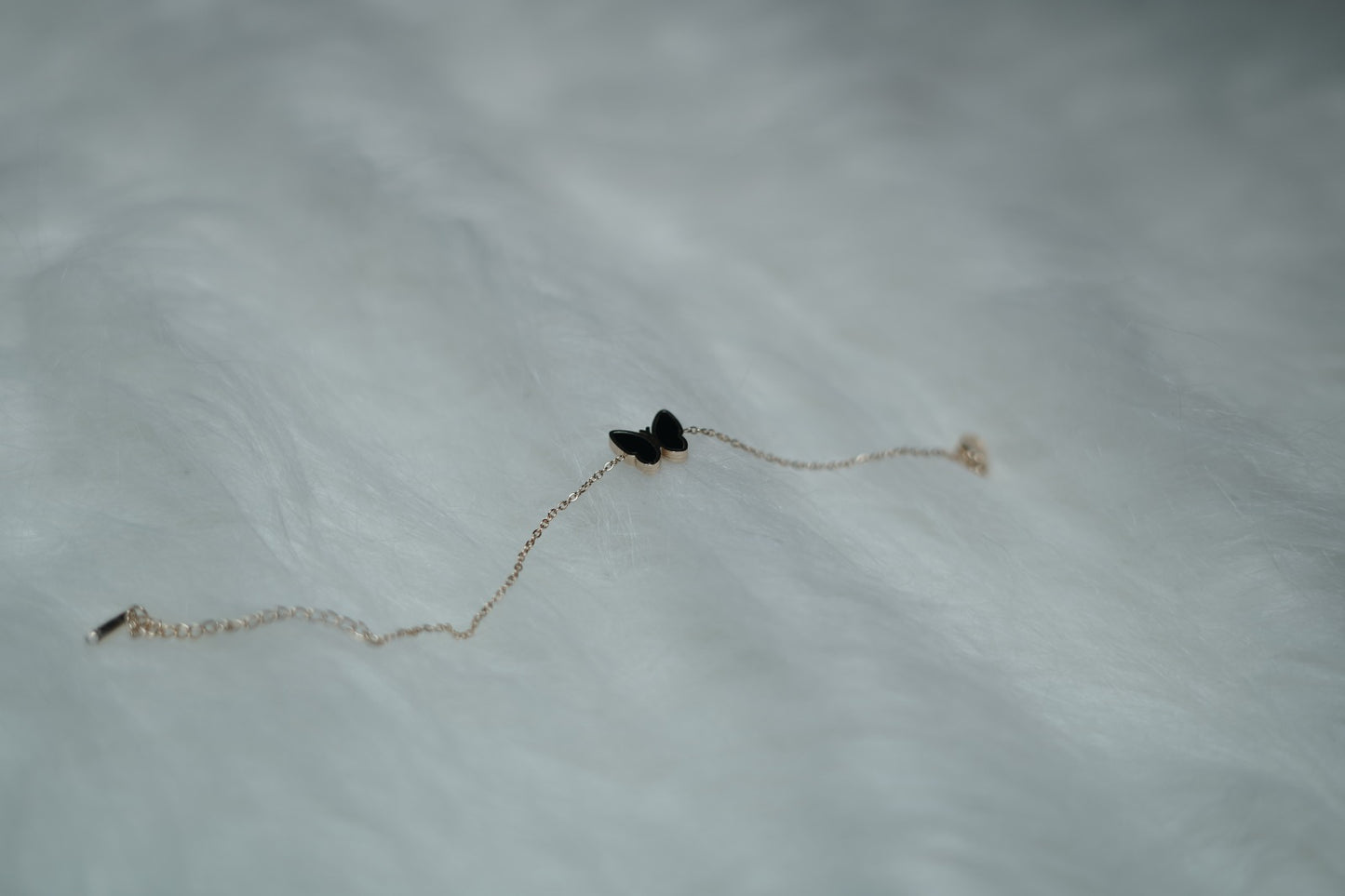Bracelet displayed with the black butterfly side turned up, laid flat on a neutral surface.