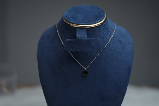 Dual Sided Halo Glow Necklace with black enamel side on display stand.