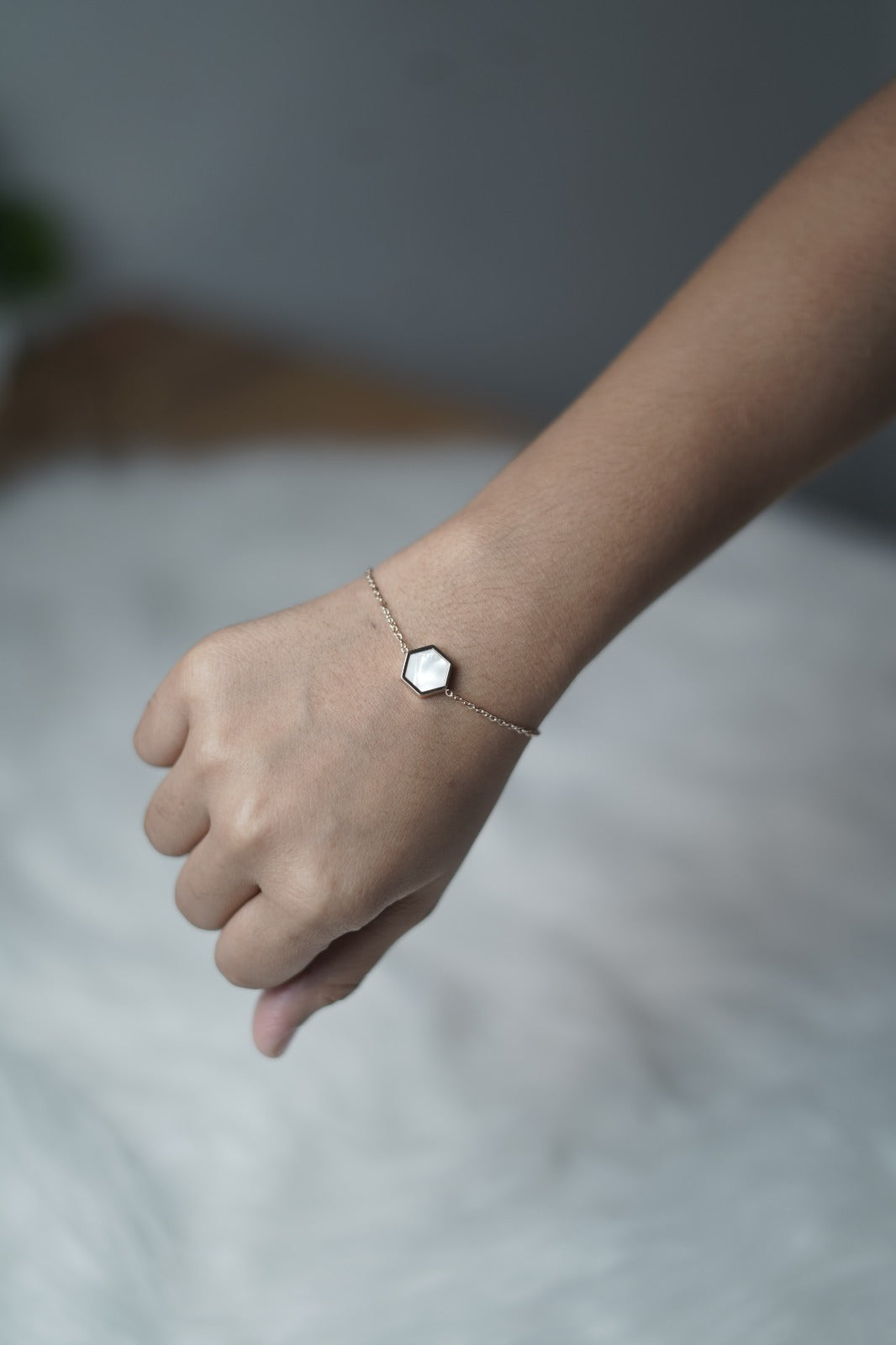 Bracelet styled with the white hexagon side visible, resting on the hand.
