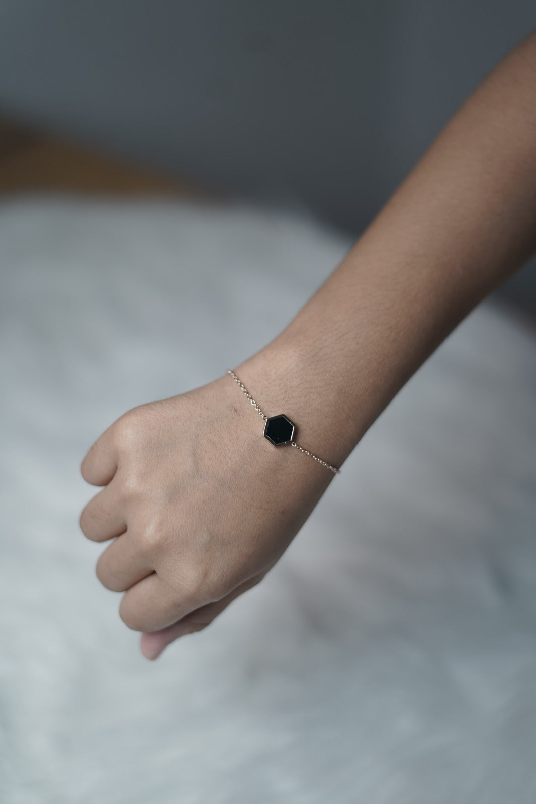 On-hand shot showing the bracelet with the black hexagon side styled outward.