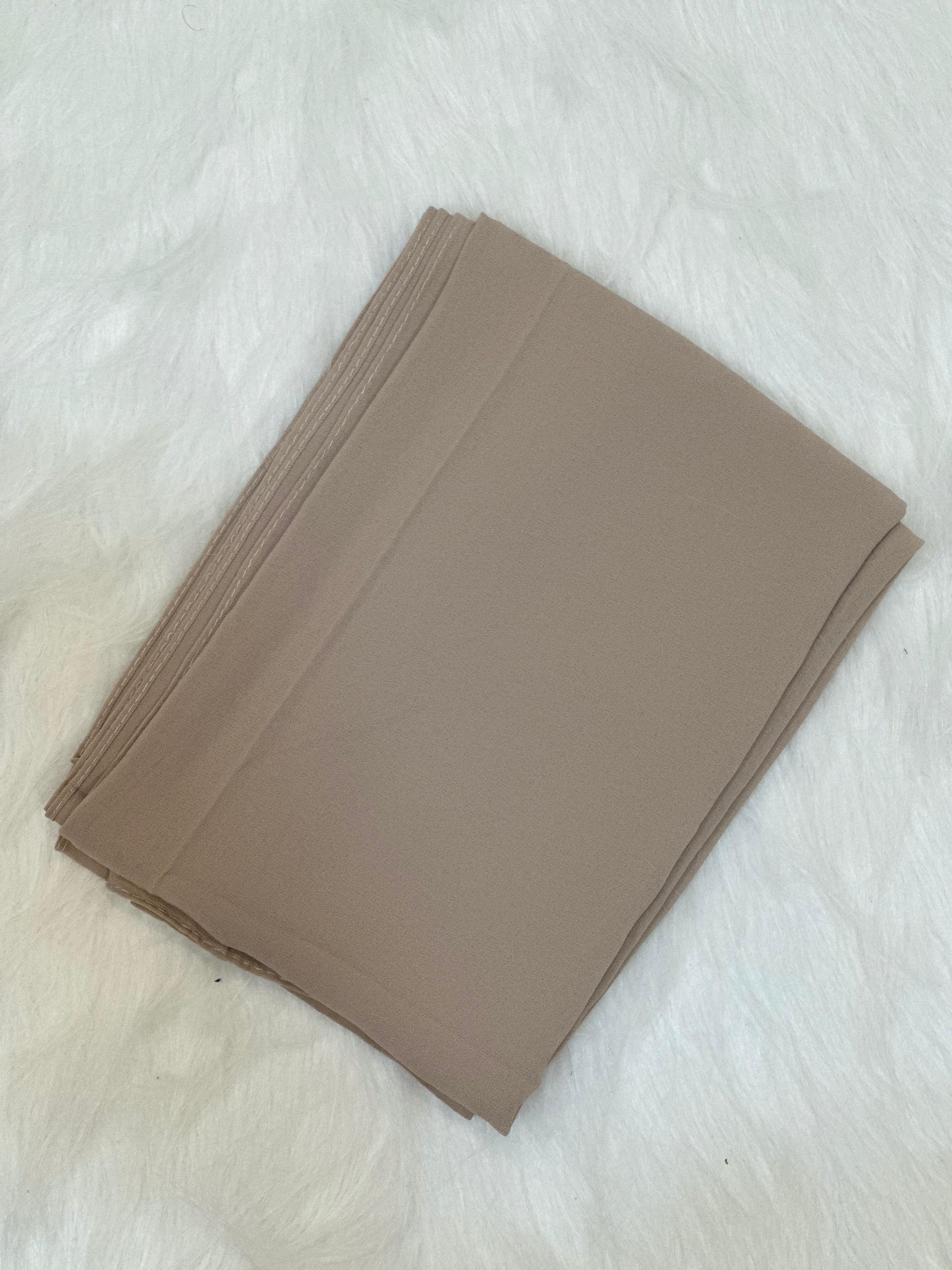 Dust Storm color Chiffon Hijab Scarf, luxury folded presentation on white faux fur background.