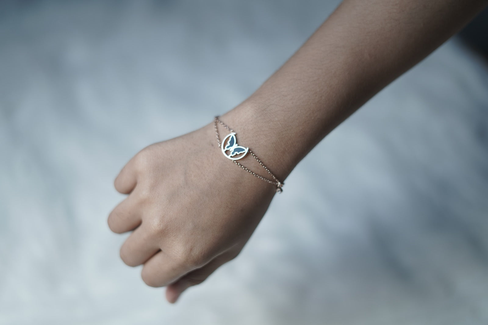 Close-up of the Eclipsed Wings Bracelet pendant and dual chain links.