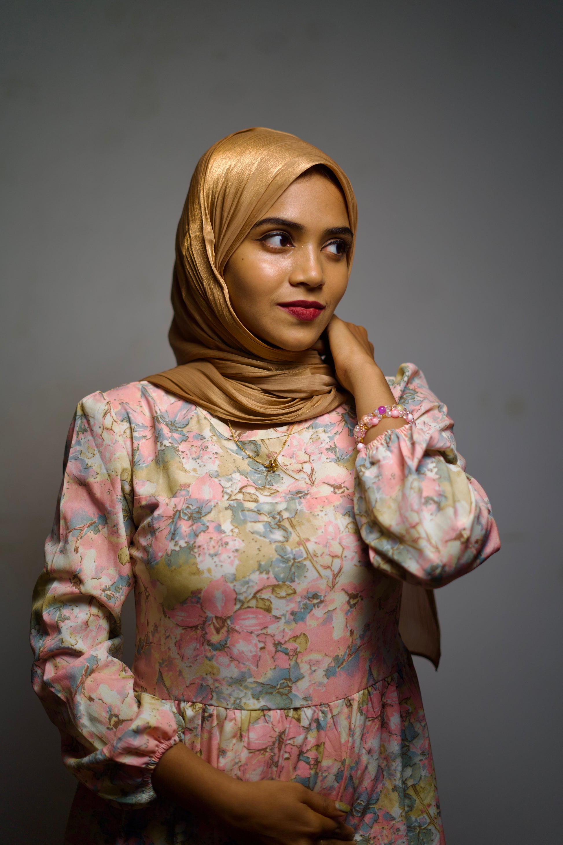 Woman in a golden shimmer scarf, styled neatly for a refined, graceful look.