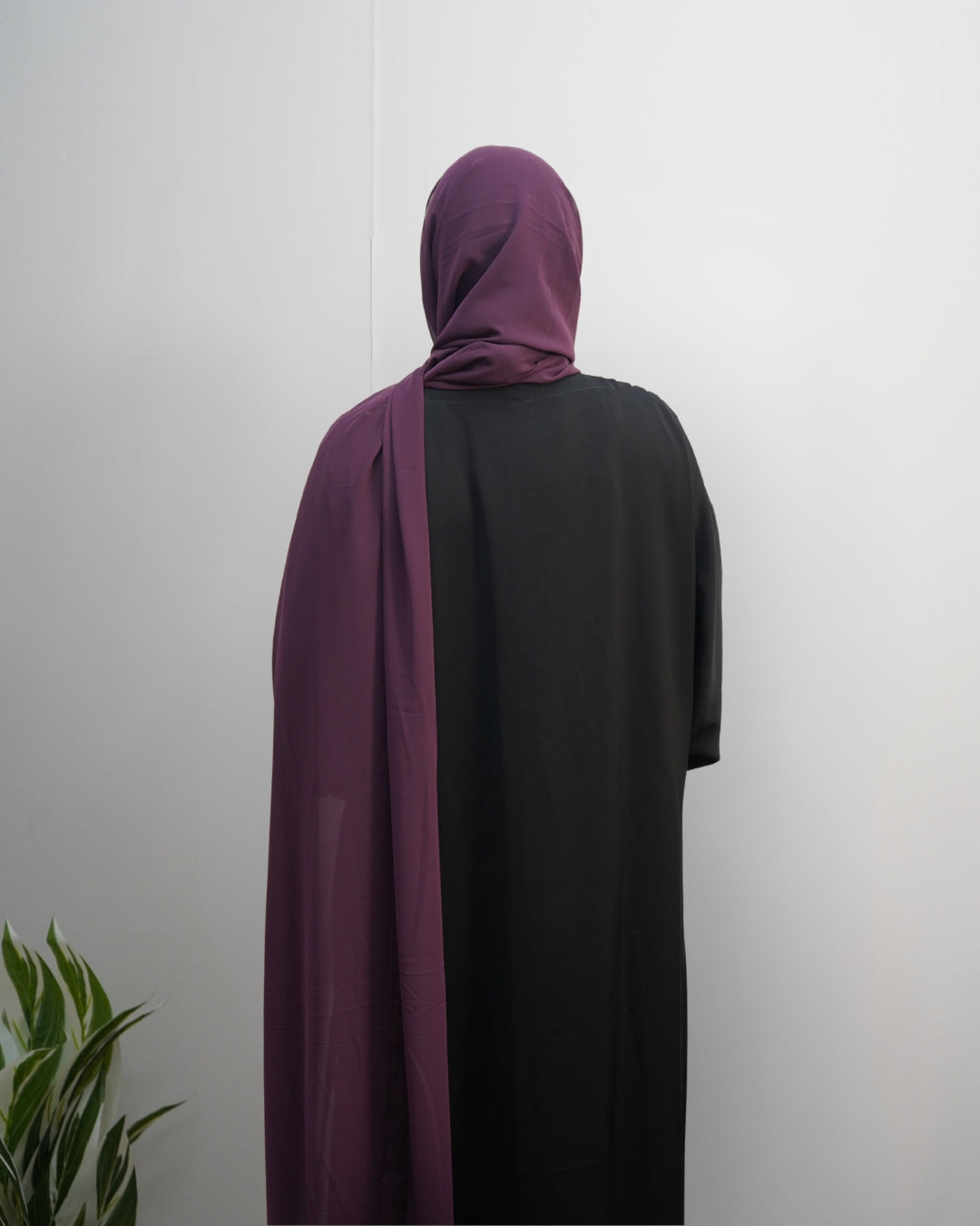 Back view of grape chiffon hijab styled with soft flowy drape.