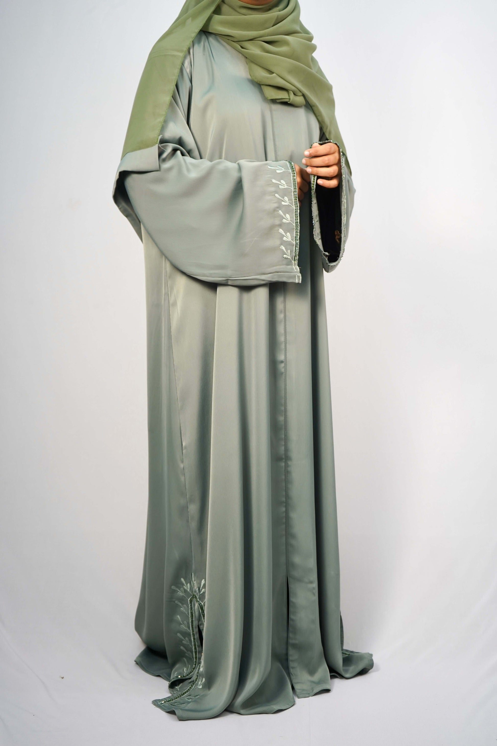 A model wearing the Tiktok Indonesian Abaya in green, showing the leaf-like embroidery on the sleeves.