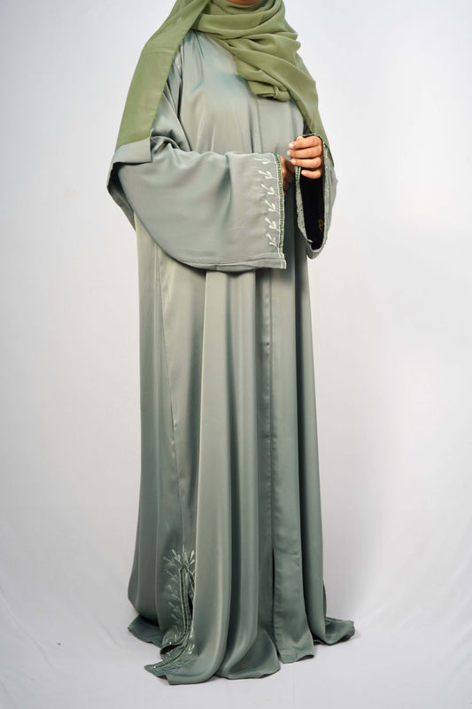 A model wearing the Tiktok Indonesian Abaya in green, showing the leaf-like embroidery on the sleeves.