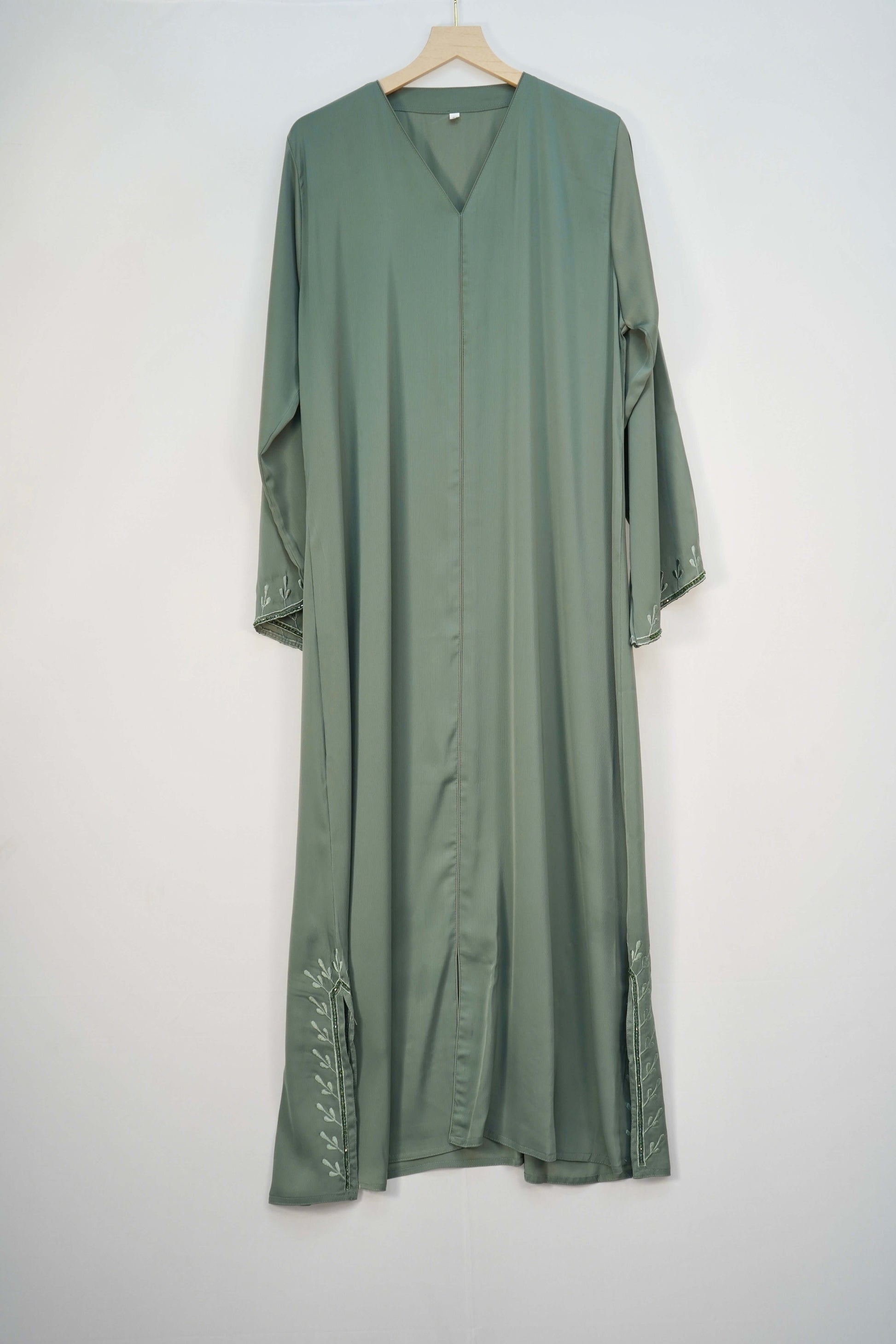 A full shot of the abaya hanging, highlighting its material, color, and design.