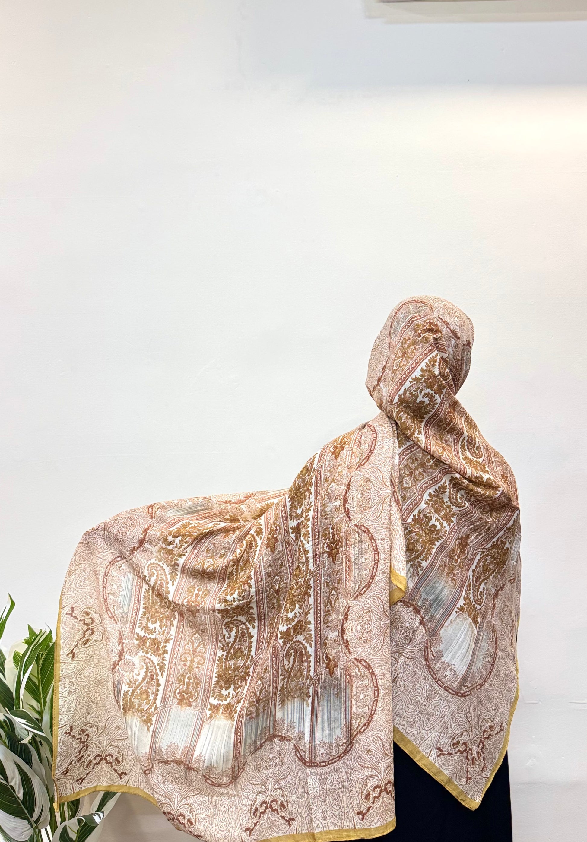 Honey yellow pashmina hijab worn with elegant draping and print details.