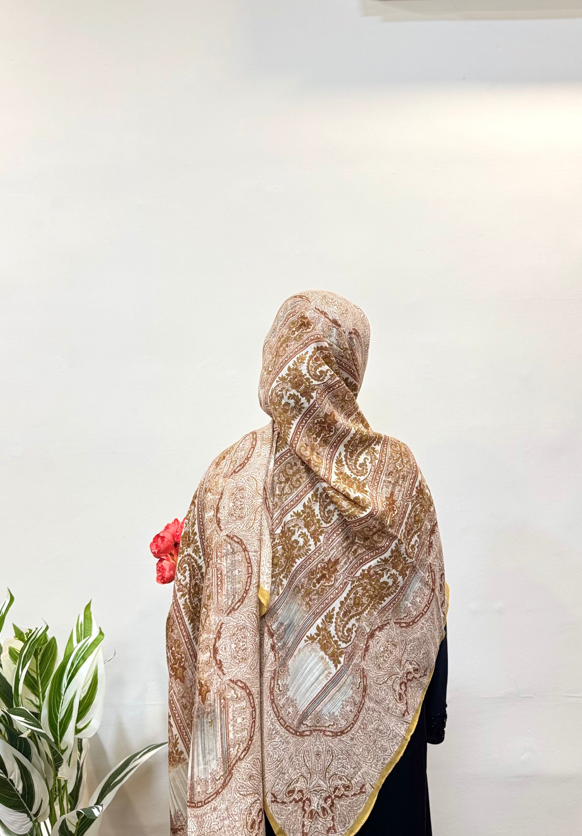 Model wearing a honey yellow pashmina hijab with printed design.