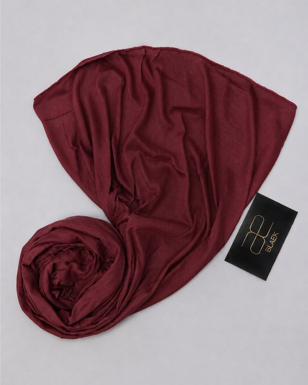 Rich wine red kids jersey hijab arranged with flowing folds and a rolled fabric detail