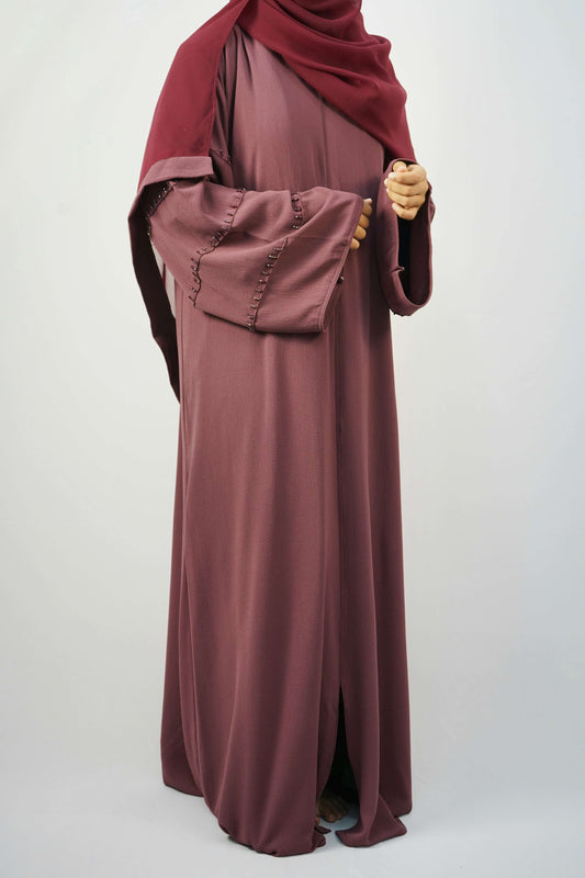A woman wearing the Korean Bubble Abaya in Old Mauve, showcasing its elegant fit and flow.