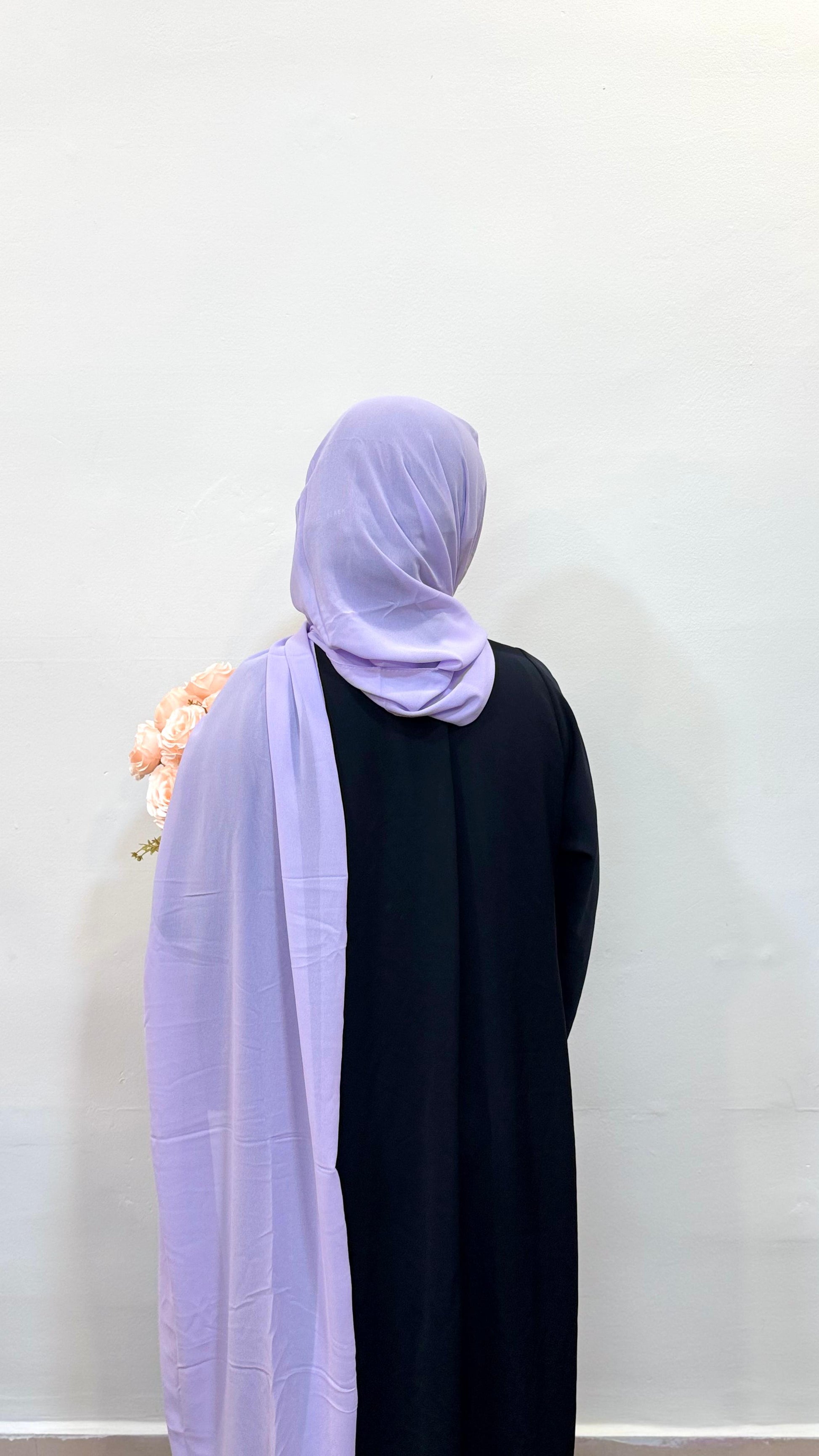 Back view of a woman wearing a lavender chiffon scarf draped elegantly over her shoulders.