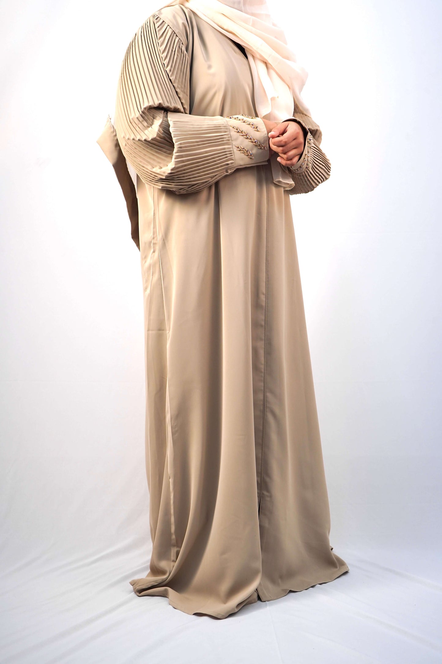 A model wearing the Korean Alqa Nidha Abaya, showcasing the pleated sleeves and matching light beige hijab.
