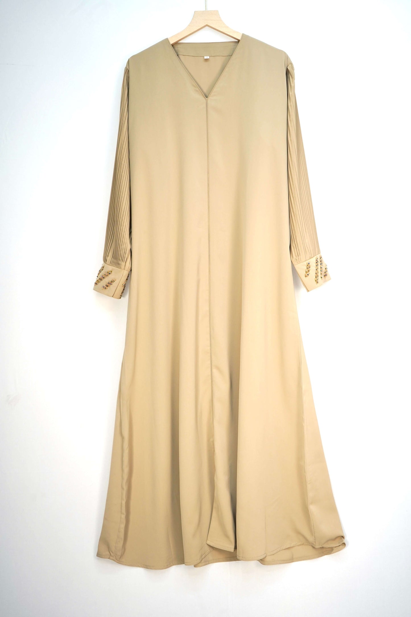 full shot of the abaya hanging, showing its color and design.