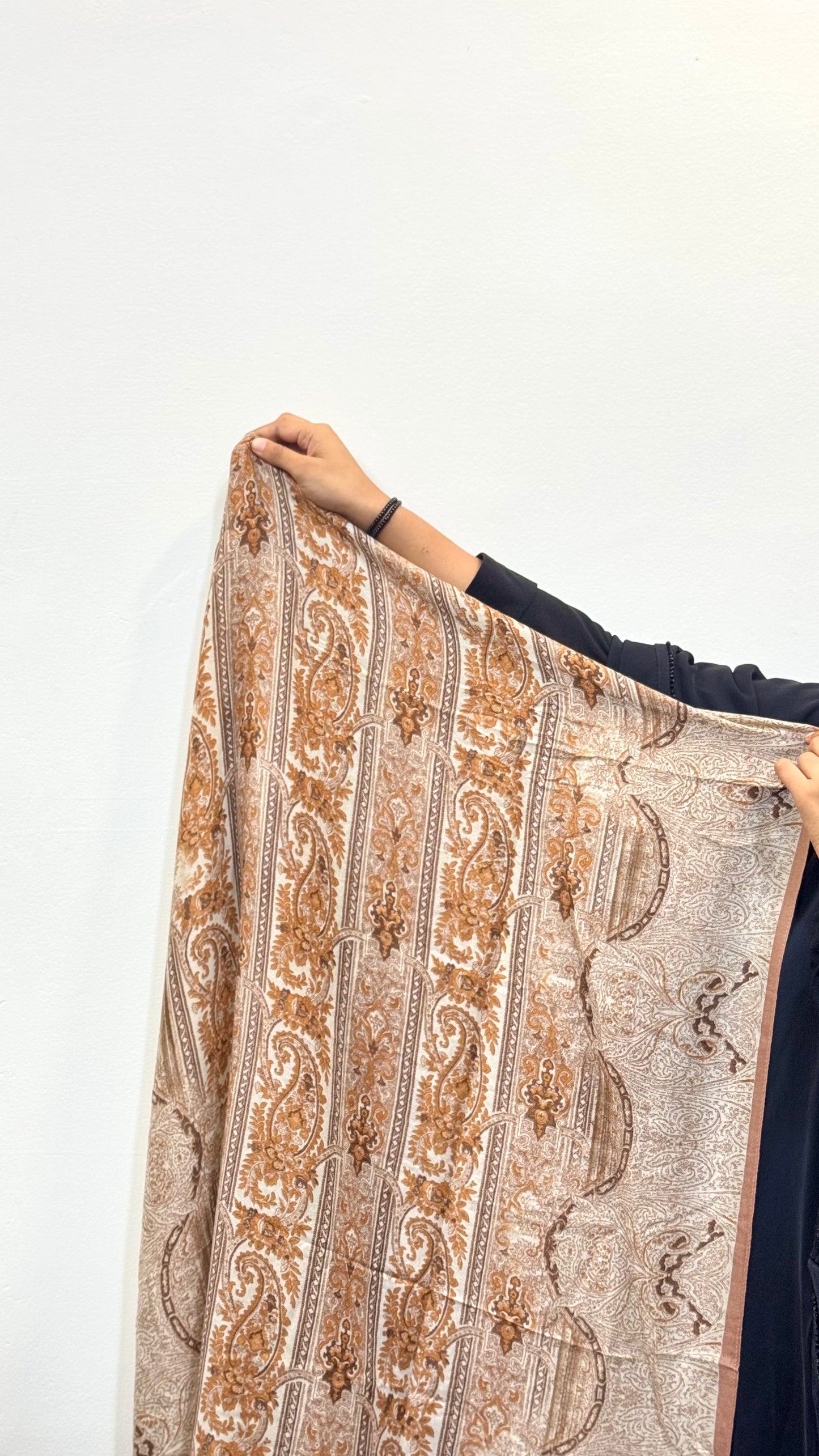 Light Brown Pashmina Print Premium Hijab laid out to display the full fabric, revealing its smooth texture and detailed gold print.