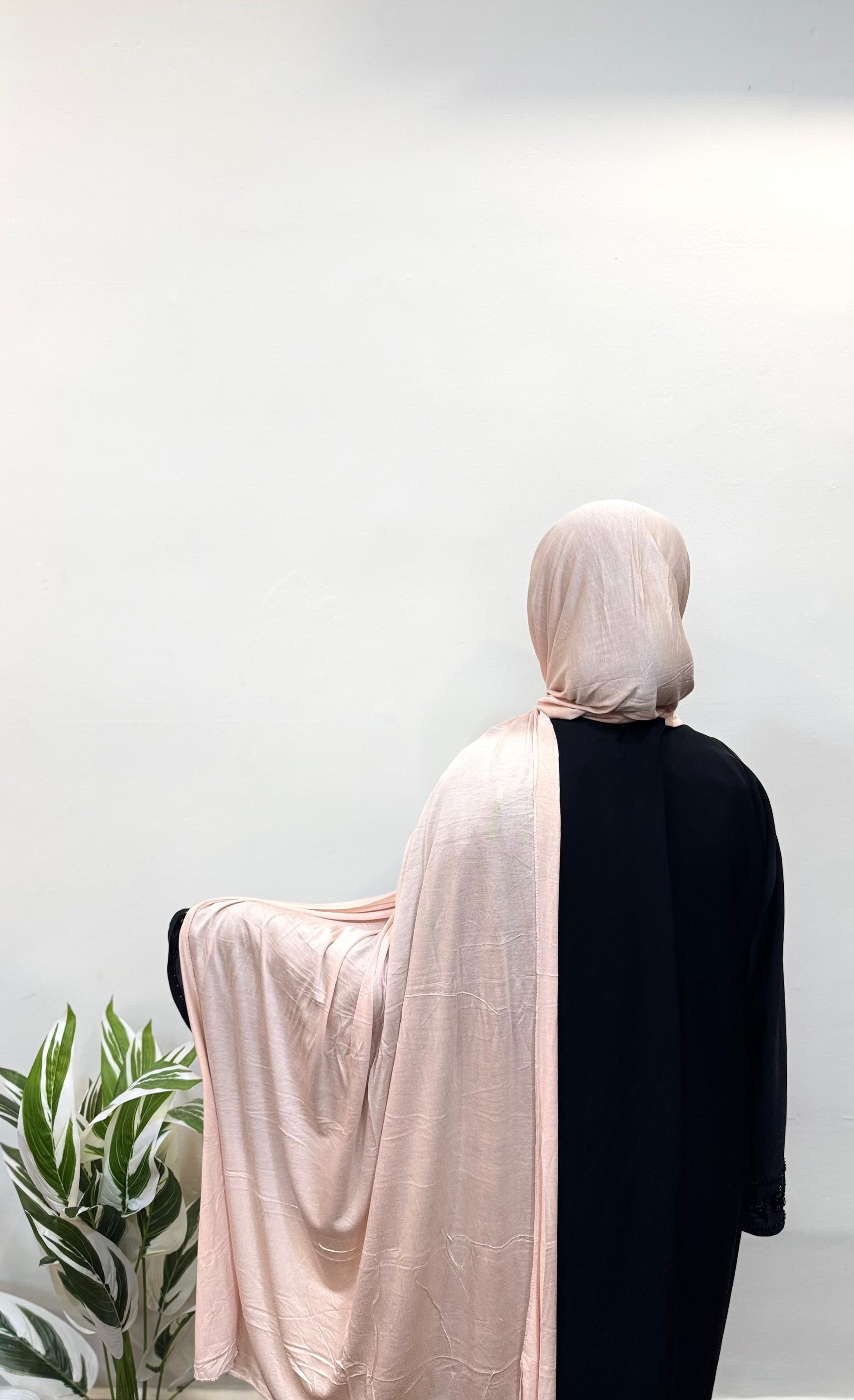 Millennial pink hijab flowing gently down the back.