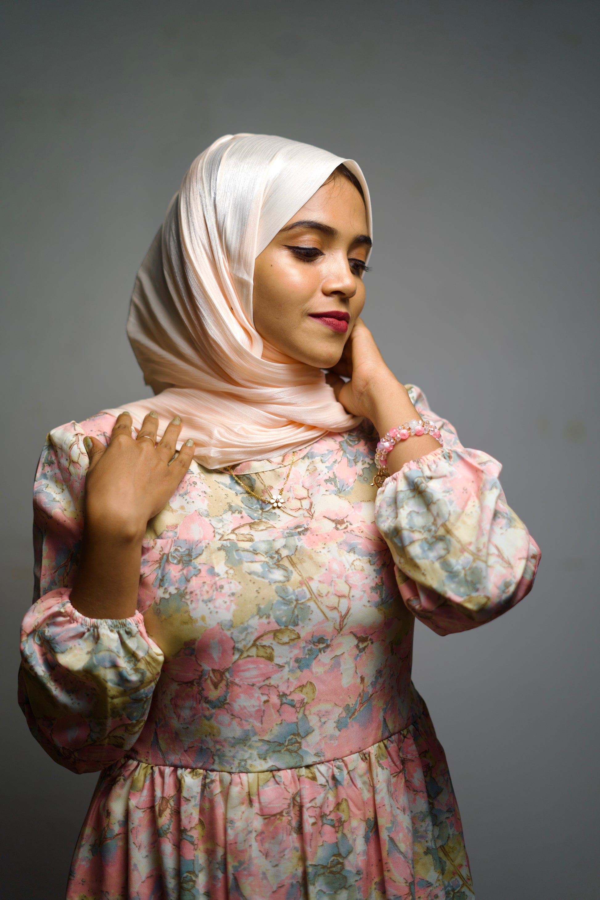 Trendy millennial pink scarf with shimmer accents, worn in a clean, fluid style.