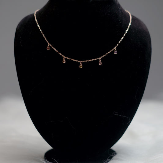 Rose gold chain with multicolor stone pendants.