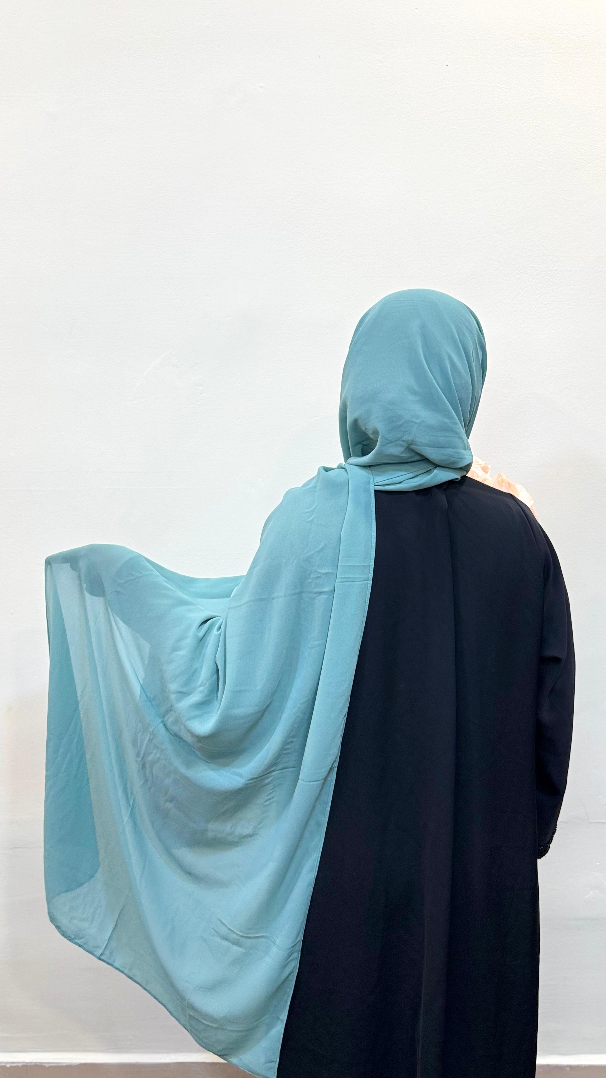 Mint chiffon scarf flowing down the back, paired with a black pardha.