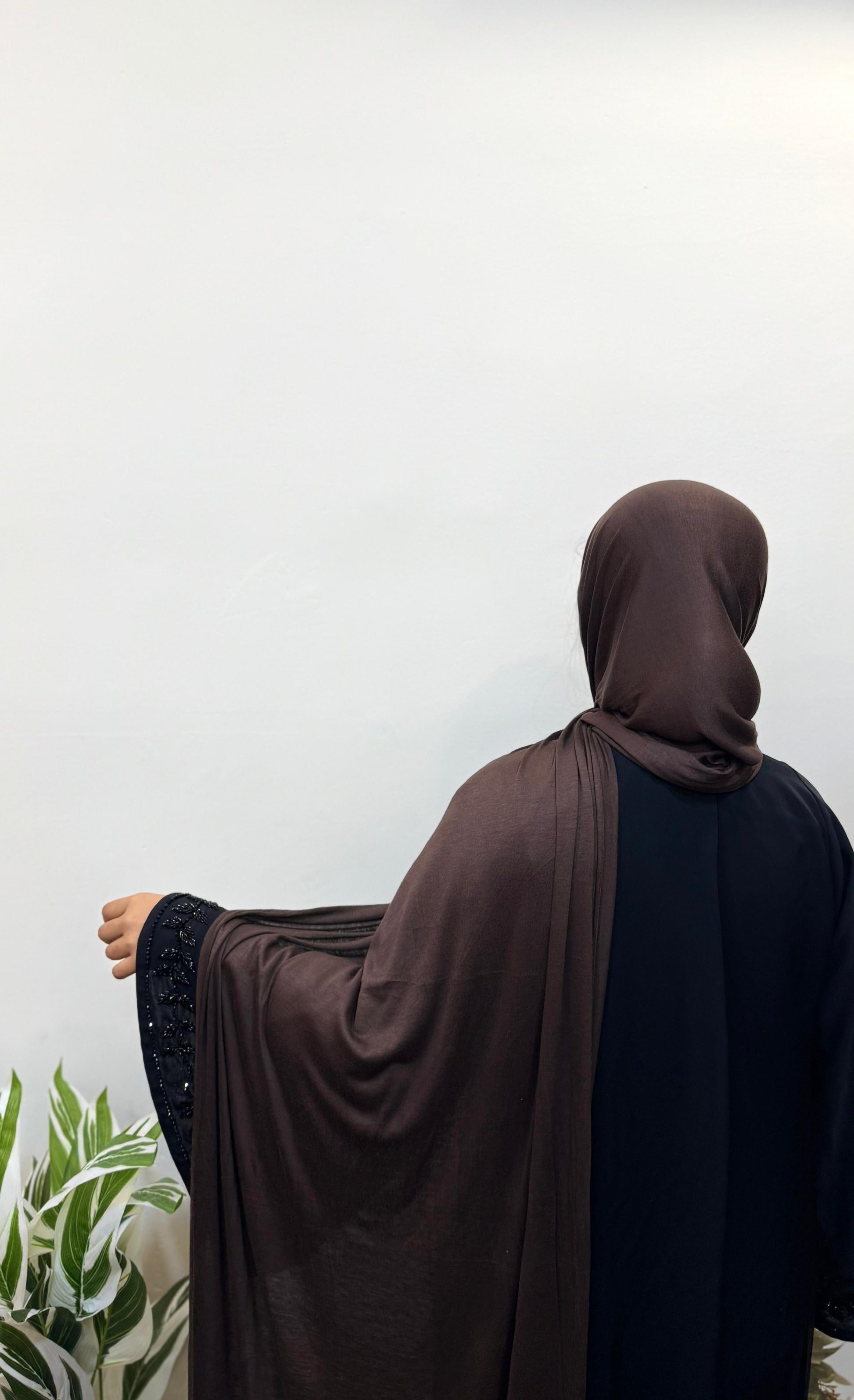 Woman in mocha jersey hijab with relaxed drape.